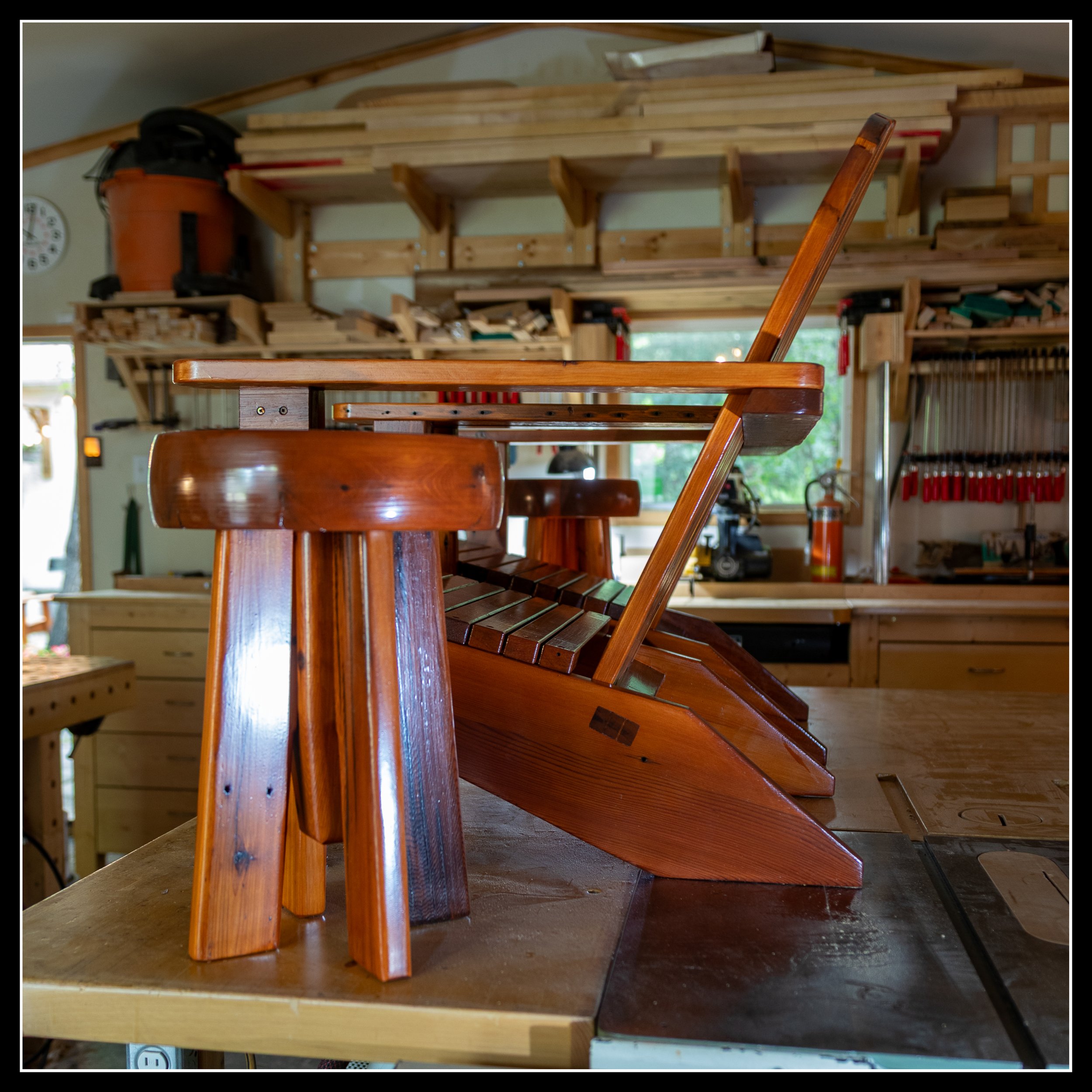 Grandpa’s cedar chair with matching cedar side table in the workshop, both finished in warm long‑oil varnish, showing smooth grain, heritage joinery, and shop craftsmanship.