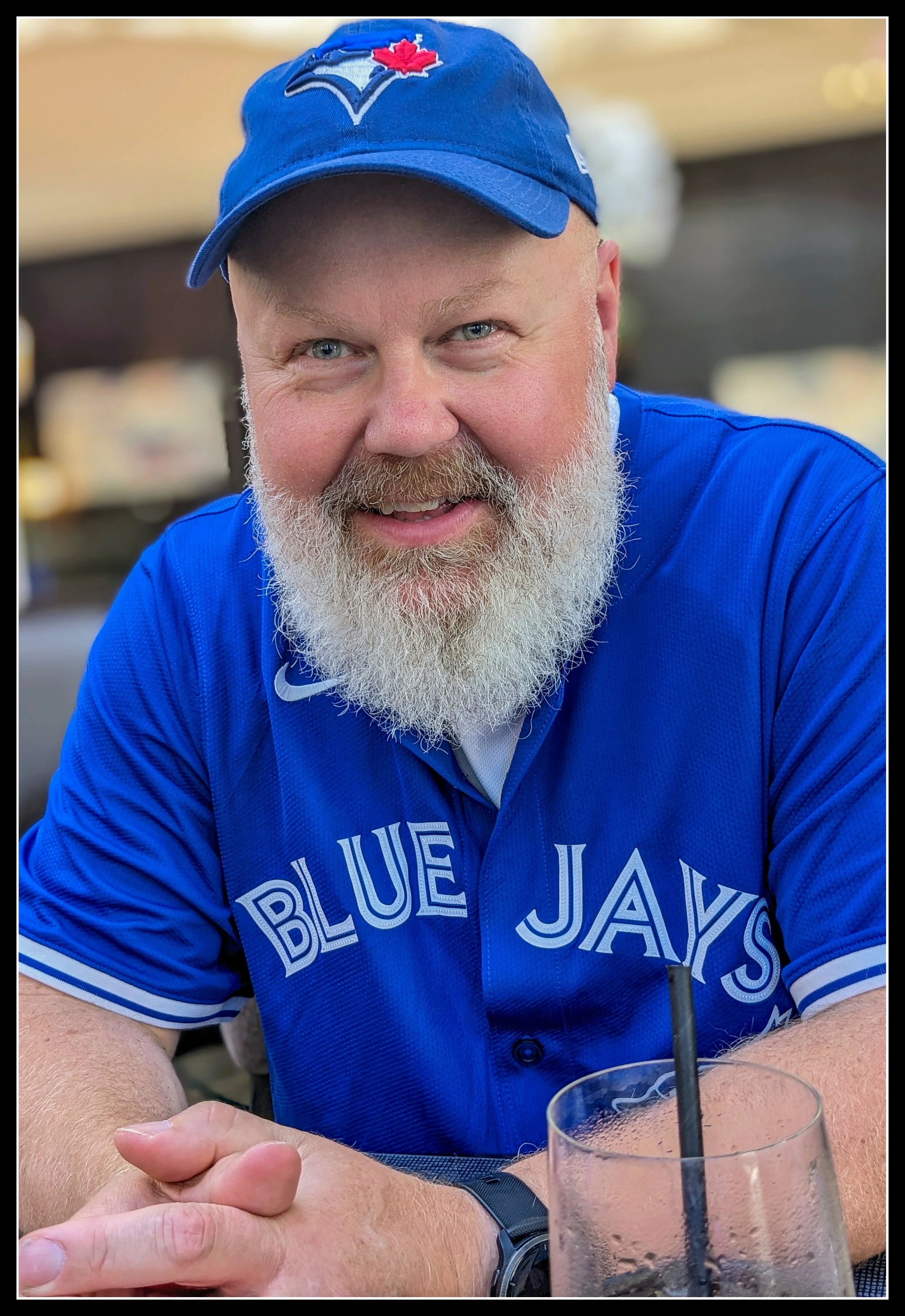Portrait of Knotty Dave wearing a Blue Jays cap and jersey, representing the craftsman behind Knotty Dave’s Fine Woodworking.