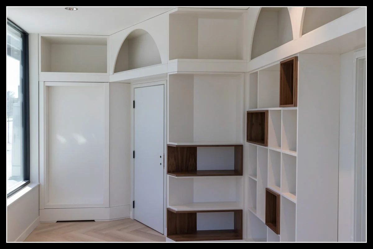 White custom shelving with hidden closet in a doctors office.