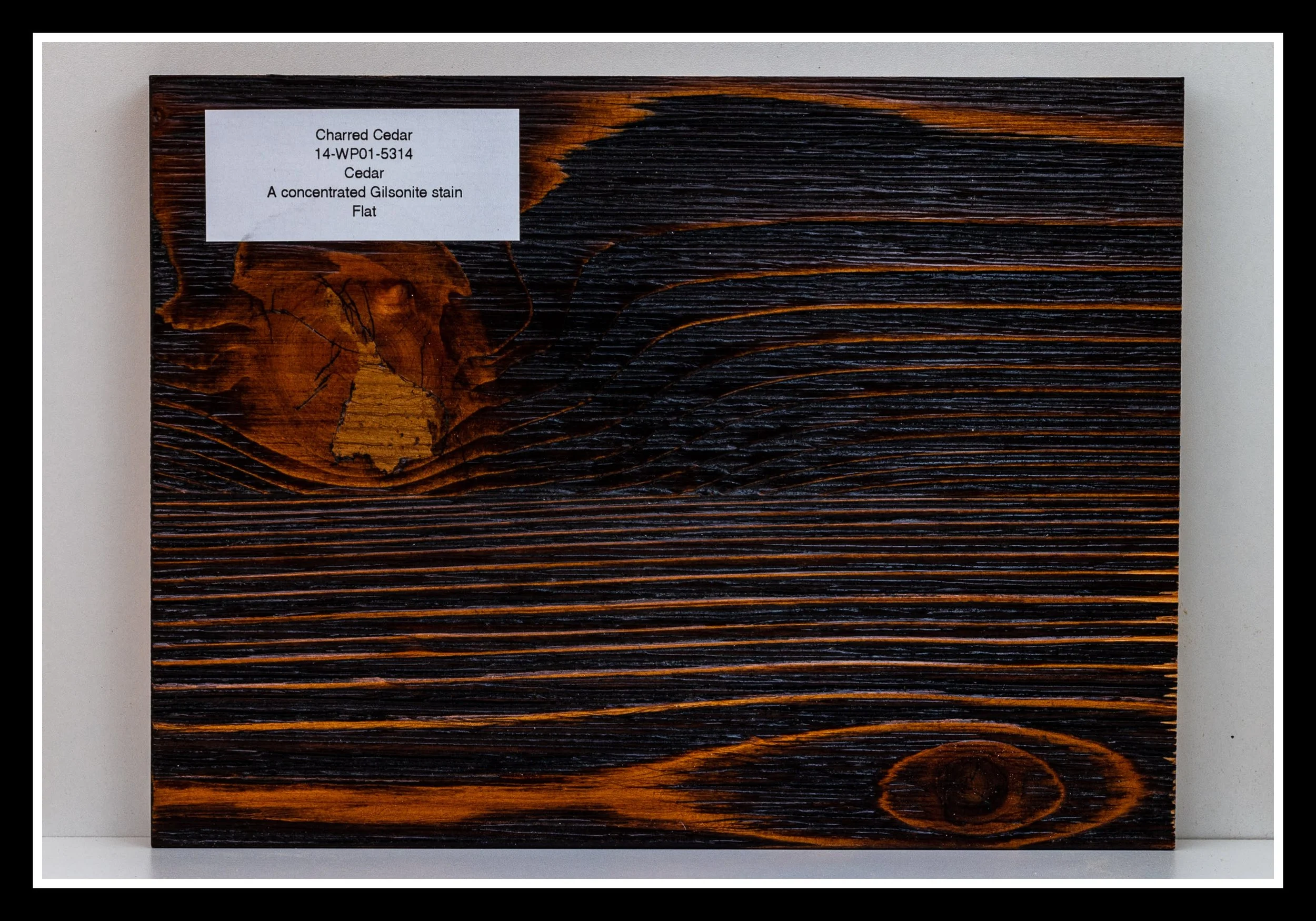 Charred cedar sample showing deep grain contrast, burned surface texture, and the rich blackened finish created by traditional charring.