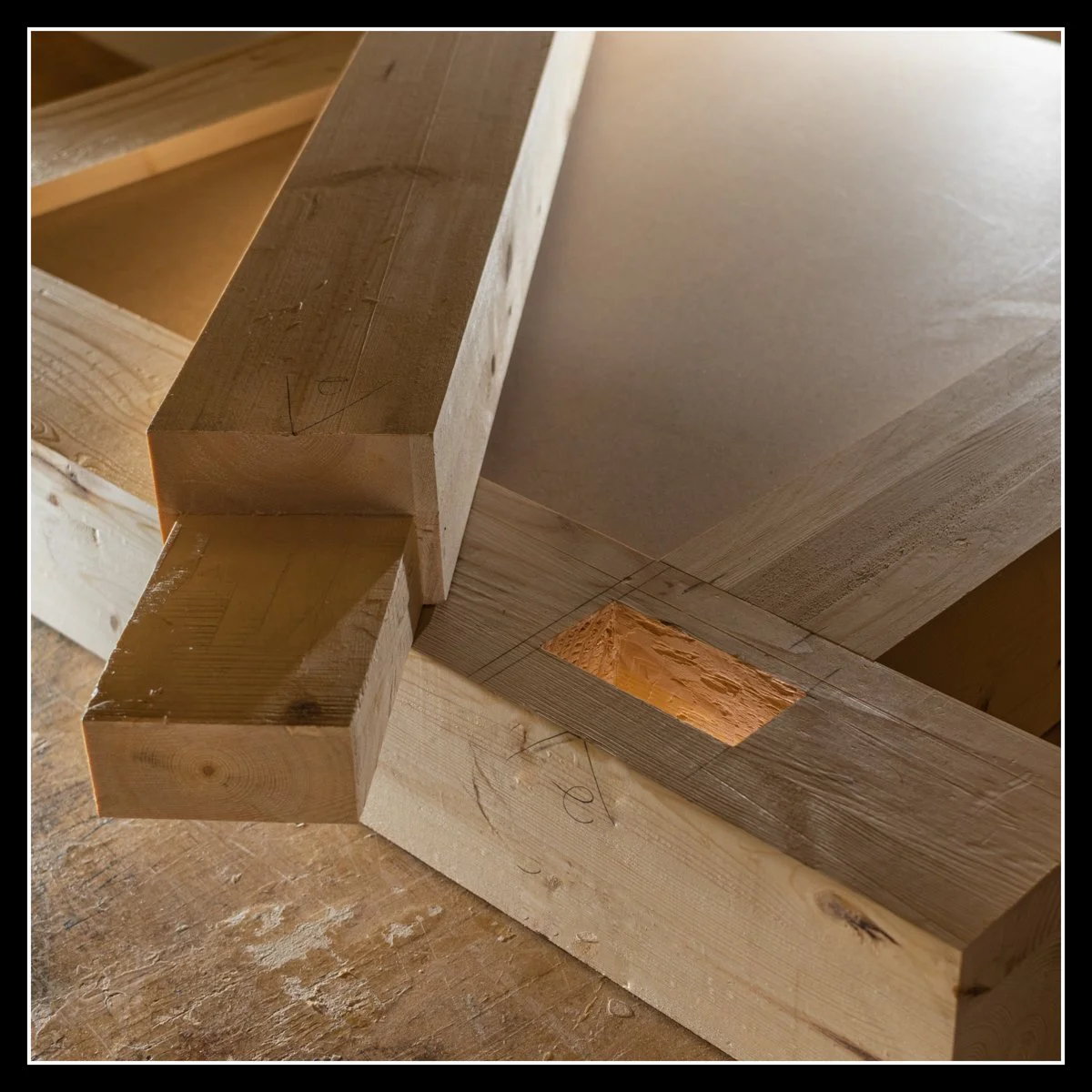 Close‑up of a spruce mortise‑and‑tenon joint on a heavy workbench frame before glue‑up, showing clean cuts, grain detail, and structural joinery.