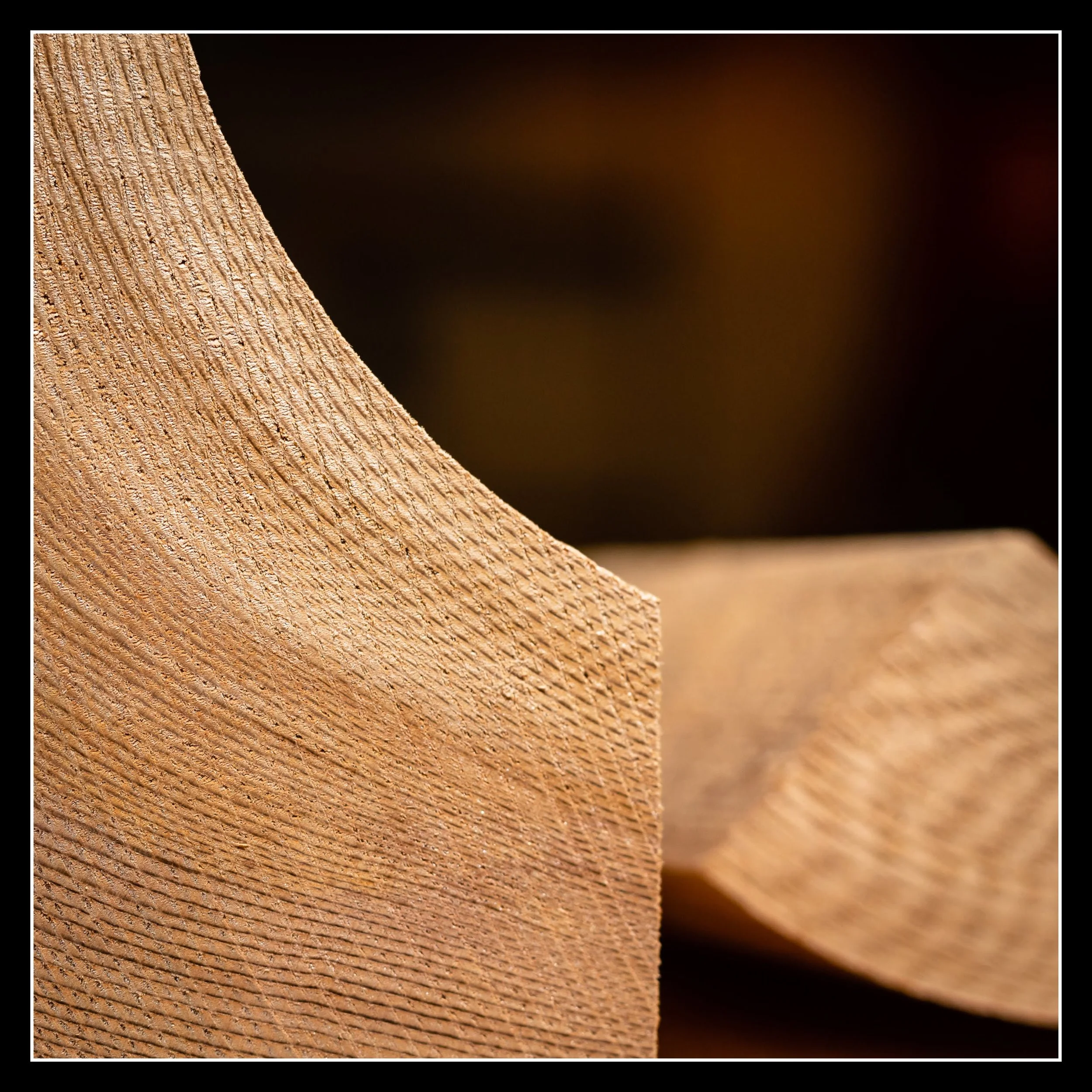 Close-up of a wooden cedar board with a textured surface, with a blurred background.