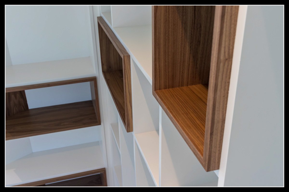 Empty wall-mounted shelves with wood finish on a white background.