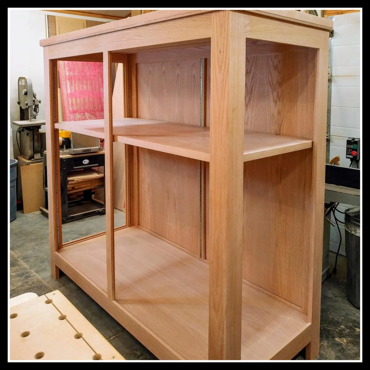 Unfinished red oak display case built for the Winnipeg Railway Museum, showing a mix of solid wood and veneer panels with clean joinery and smooth surfaces in a workshop setting.