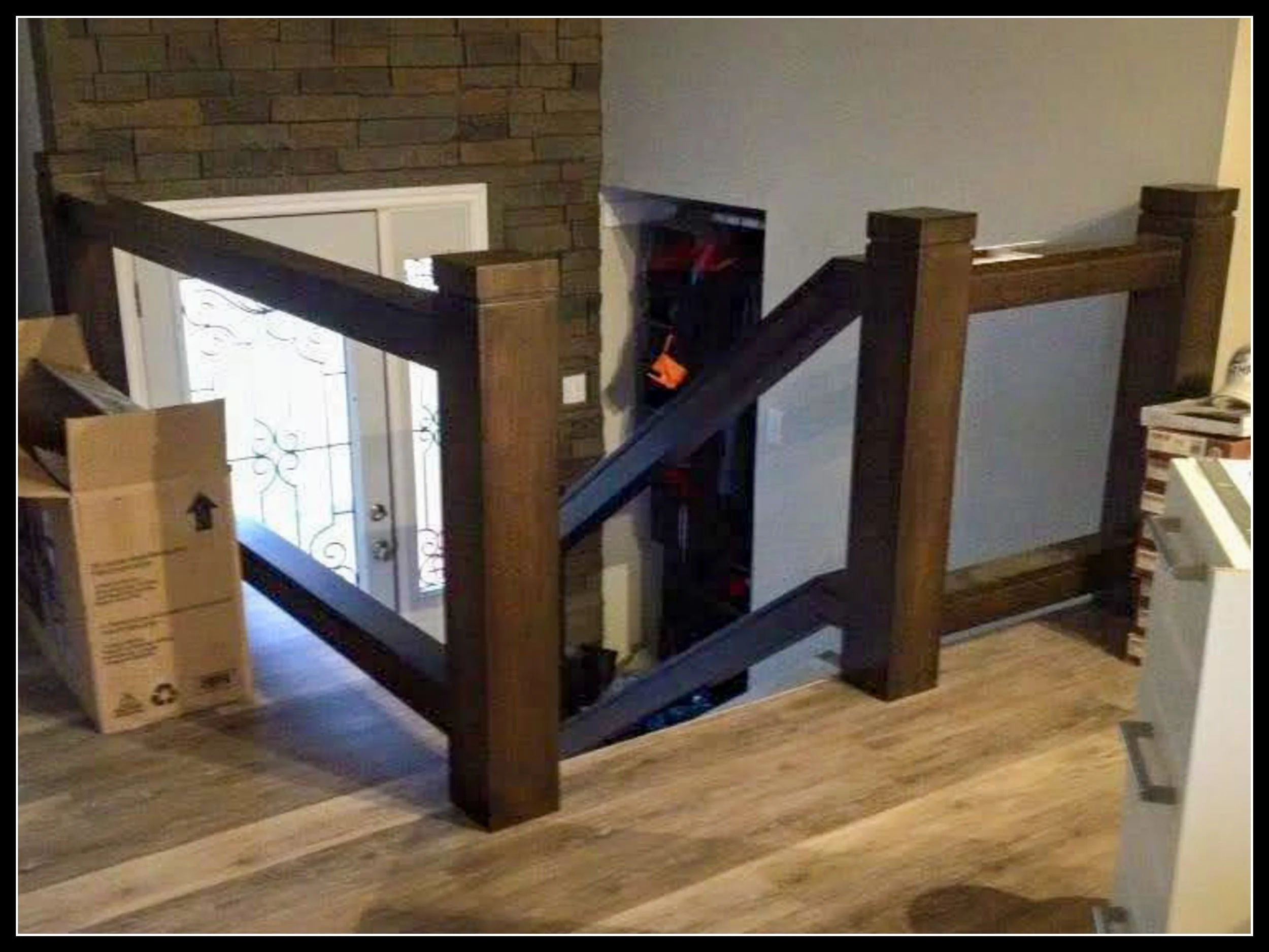 Solid walnut stair rails in installation phase, hardwood posts and rails awaiting glass panels for heirloom entryway design.