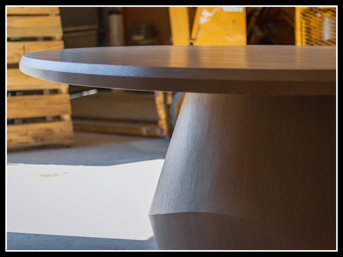 Red oak custom table, oval in shape, curved base.