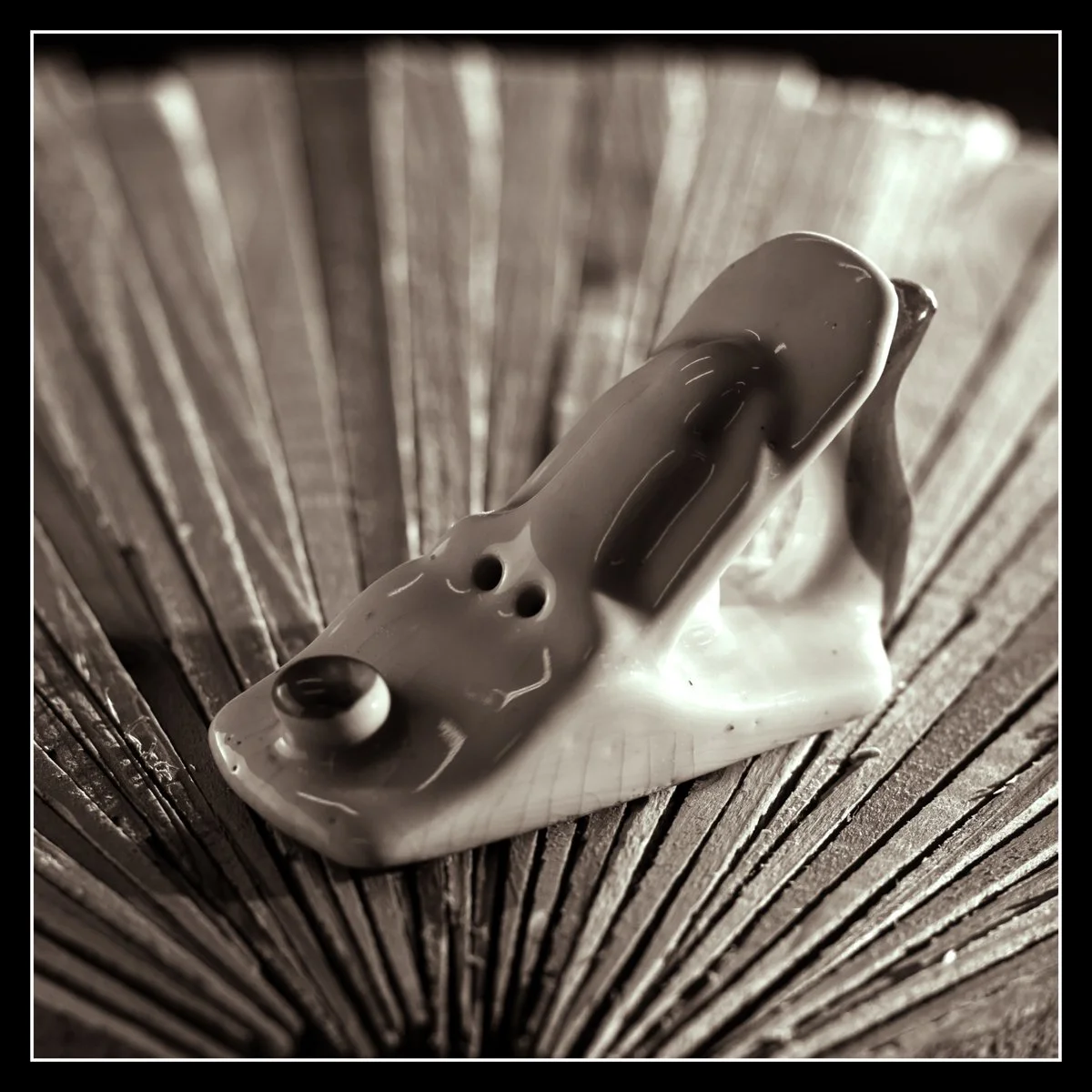 Porcelain handplane resting on neatly stacked cedar shims, a small keepsake from the early days of my woodworking journey.