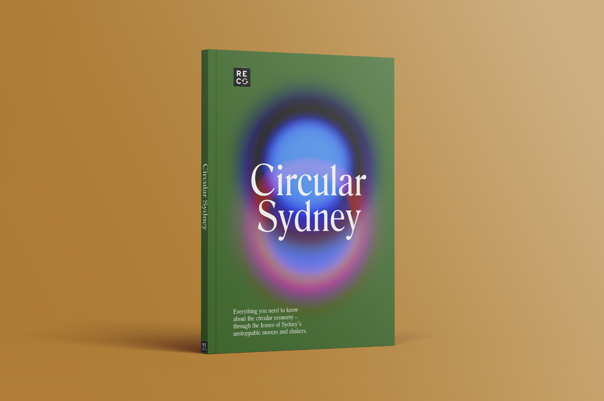 A green book titled 'Circular Sydney' with a colorful, blurred circular design on the cover, standing upright on a light brown surface with a gradient background.