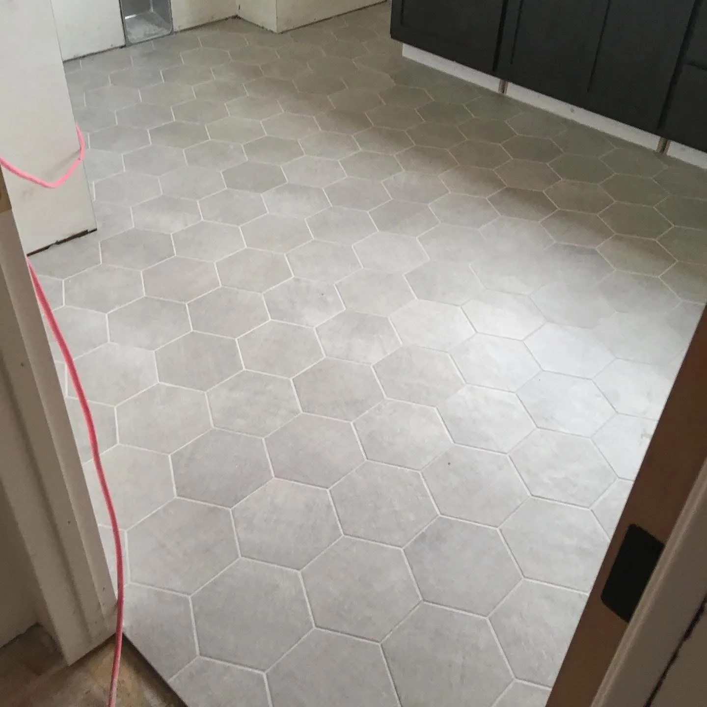 White hexagon tile flooring in a kitchen.