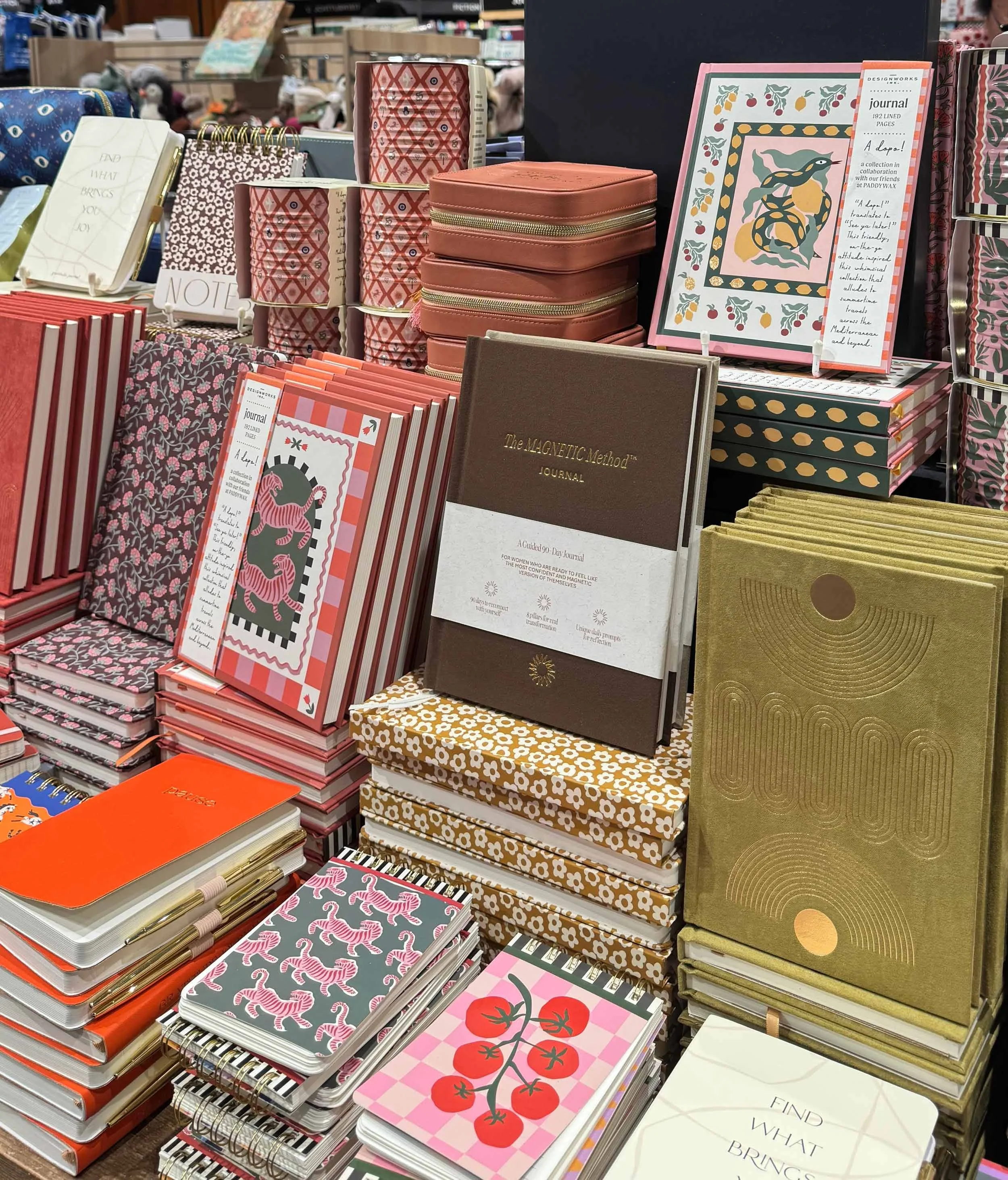 A display of notebooks and journals with various colorful and patterned covers in a store.