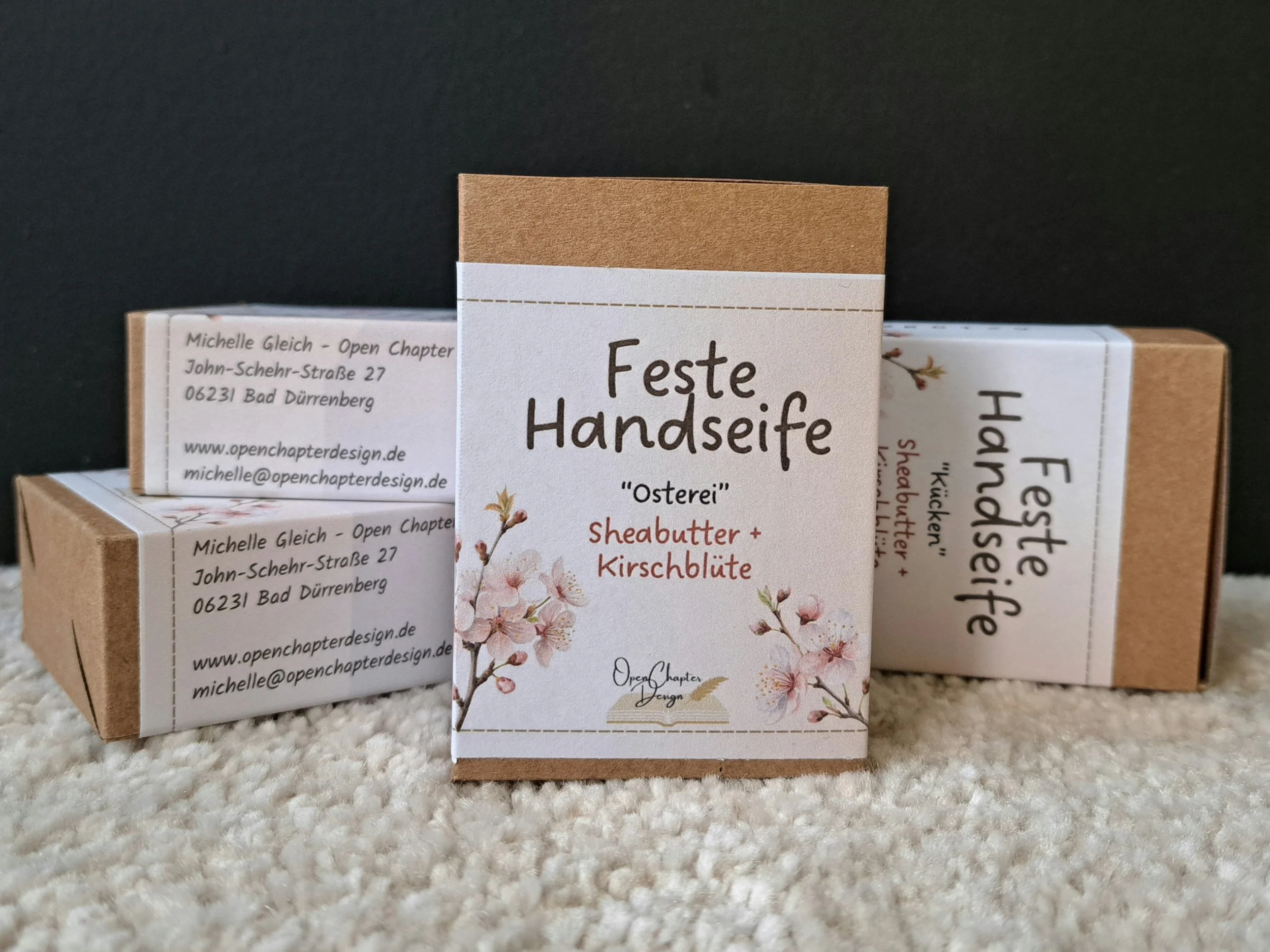 Verpackungen der Seife Kirschblüte, 3 liegen im Hintergrund, 1 steht im Vordergrund