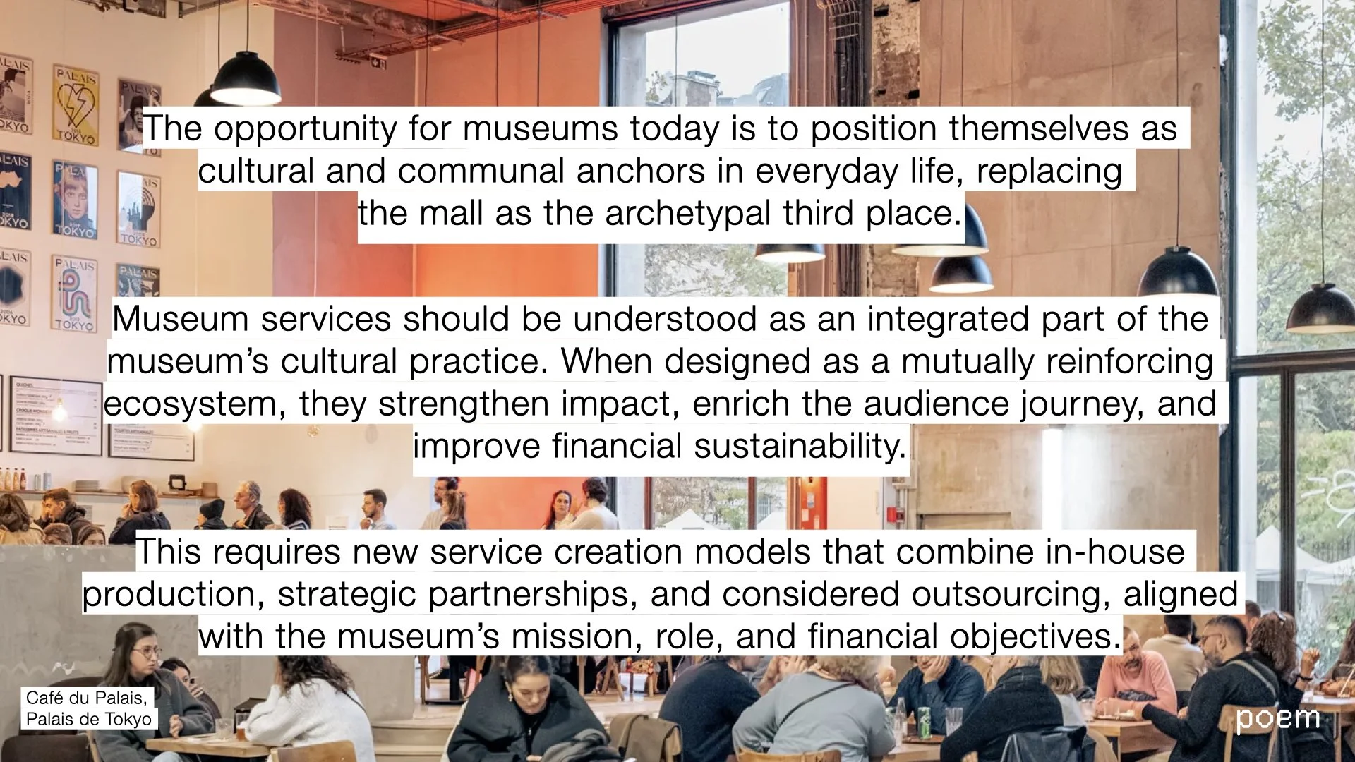 Interior of Café du Palais at Palais de Tokyo with people sitting at tables, wall art on the left, large windows with visible trees outside, and black hanging pendant lights.