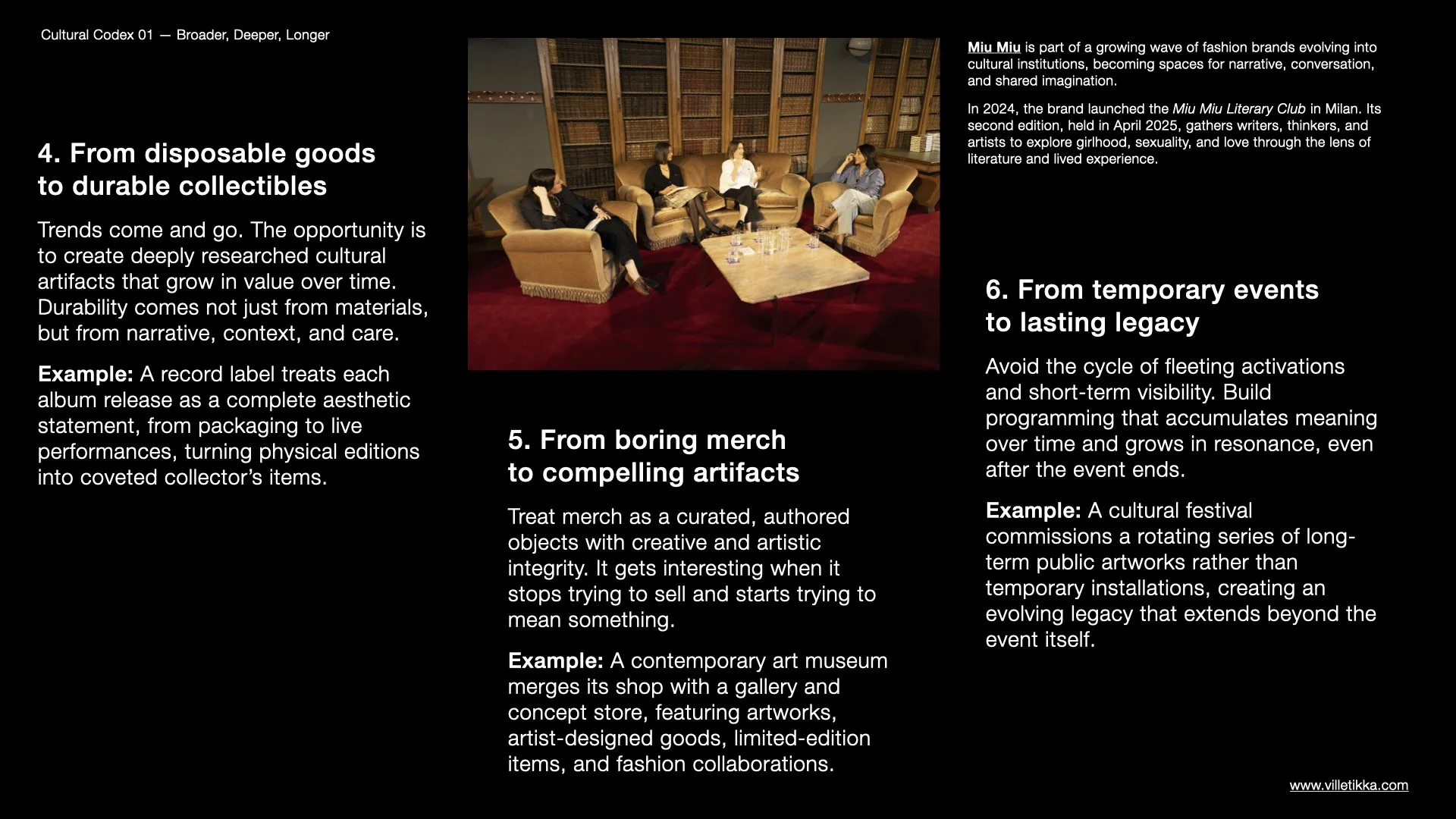 A beige sofa set with four women sitting and talking in a room with wooden bookshelves. The scene appears to be in a library or a cozy reading space with warm lighting.