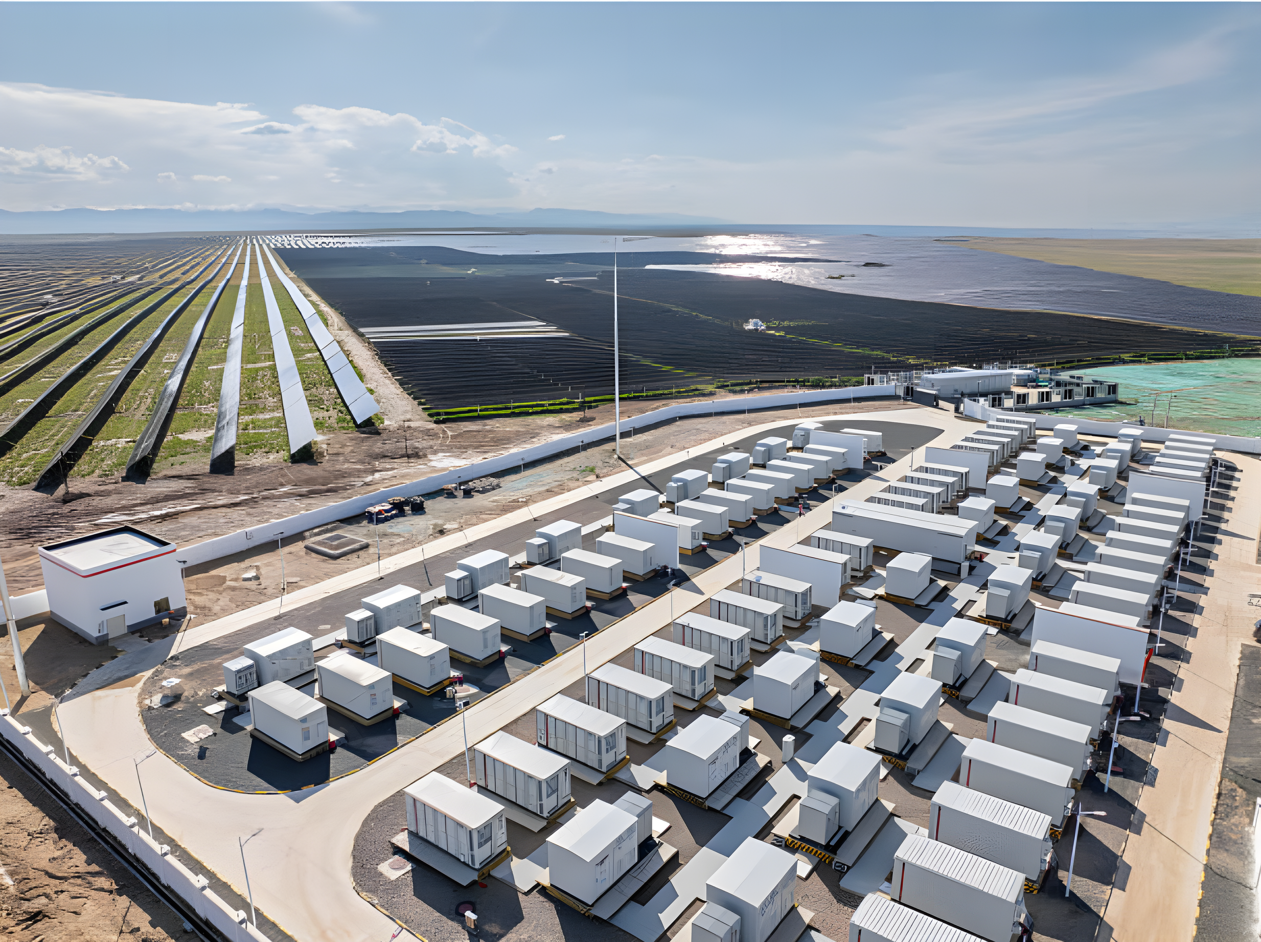 A large solar farm with numerous white solar containers and panels, adjacent to an array of solar panels on farmland near a body of water.