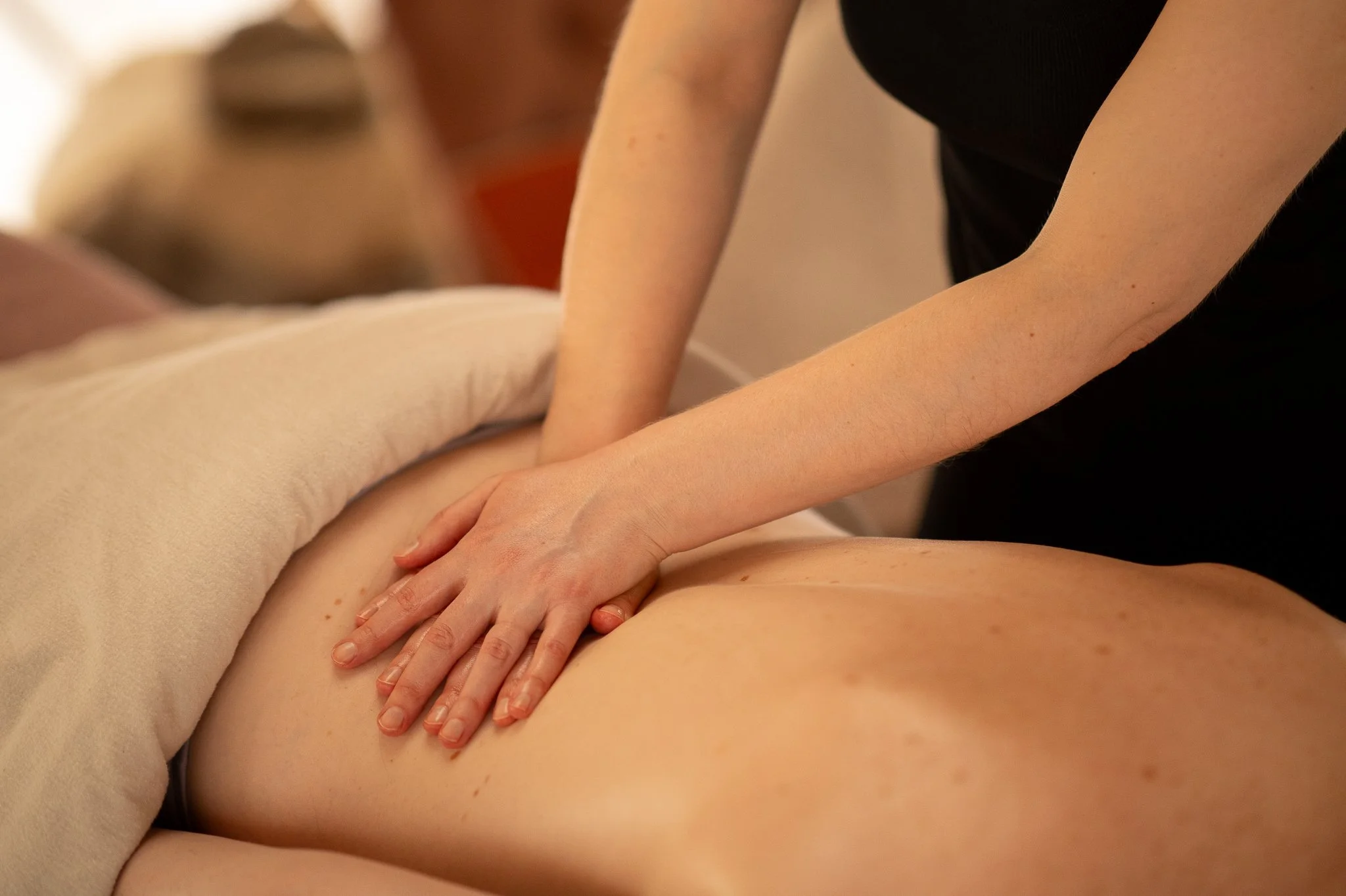 A person receiving a massage on their back from a massage therapist in a spa or massage setting.