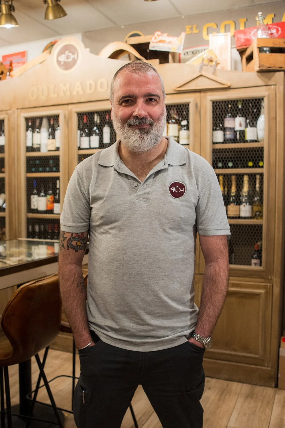 Jose Abad, en El Colmado con estanterías de madera detrás.