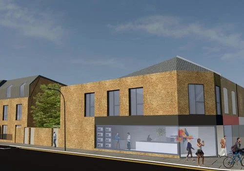 A modern brick building with large windows on a city street, with people walking and biking in front of it.