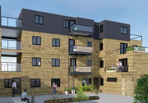 Modern residential apartment building with brick and black panels, balconies, and people outdoors.