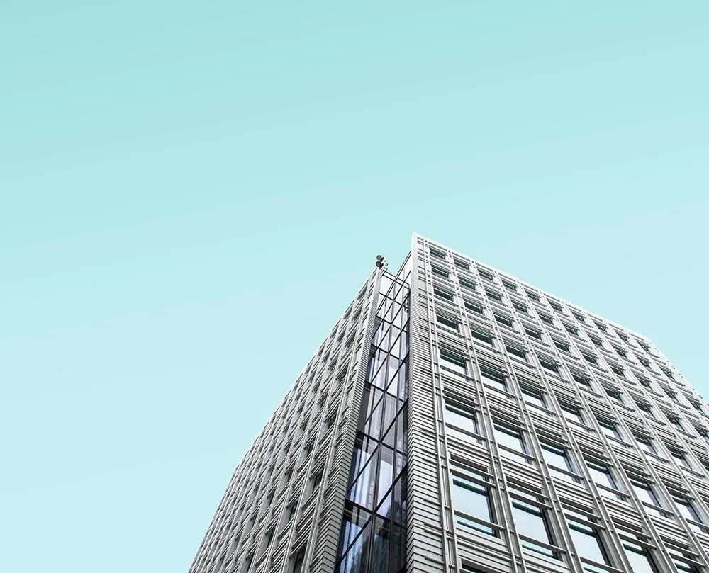 Close-up view of a modern office building against a clear blue sky.