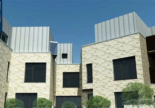 Modern residential buildings with brick lower levels and metal upper structures, with trees in the foreground and a clear blue sky.