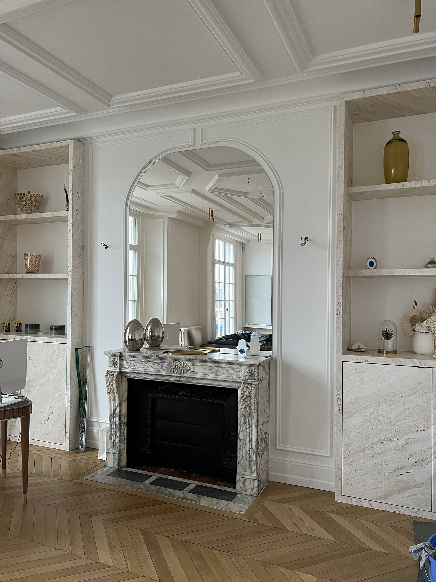 Miroir découpé sur mesure au dessus d'une cheminée en marbre dans un appartement à moulures