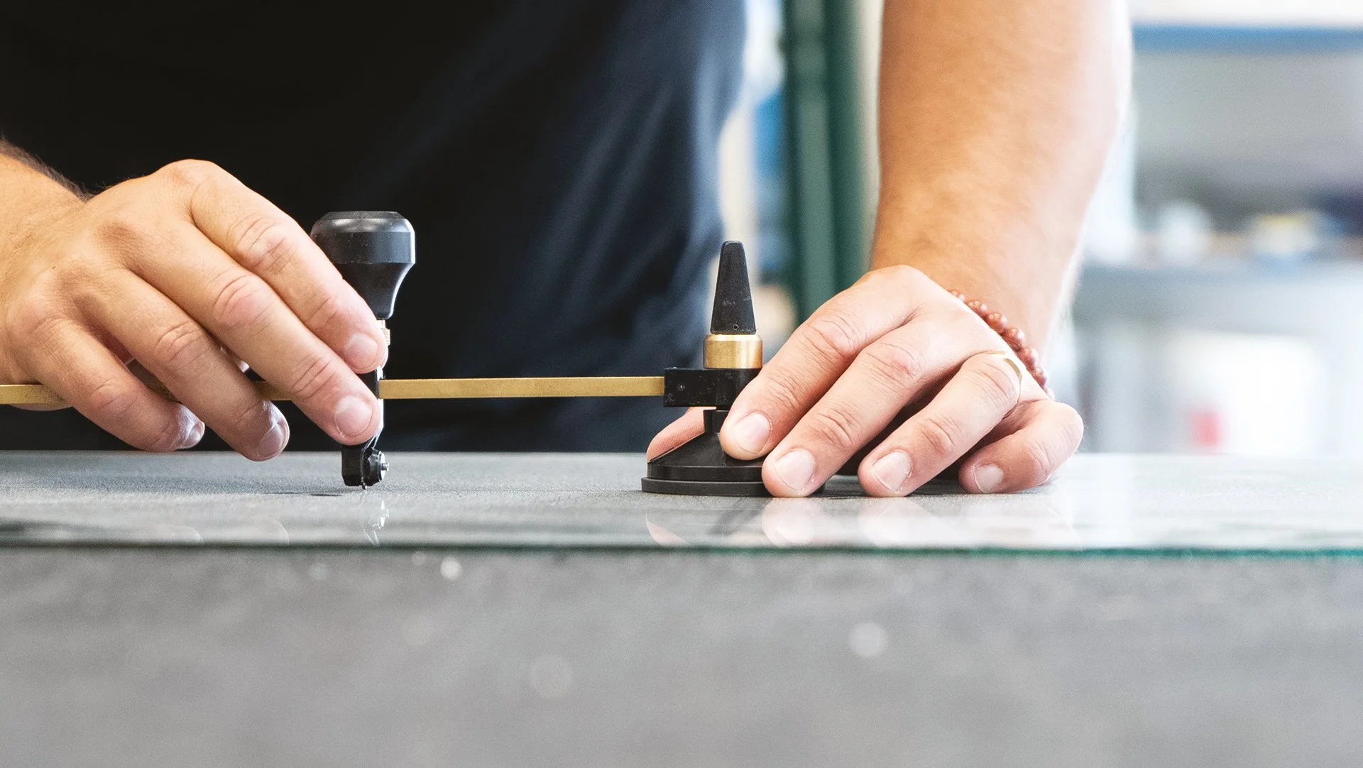 Une personne ajuste une ligne de coupe à l'aide d'un appareil de précision sur une surface.