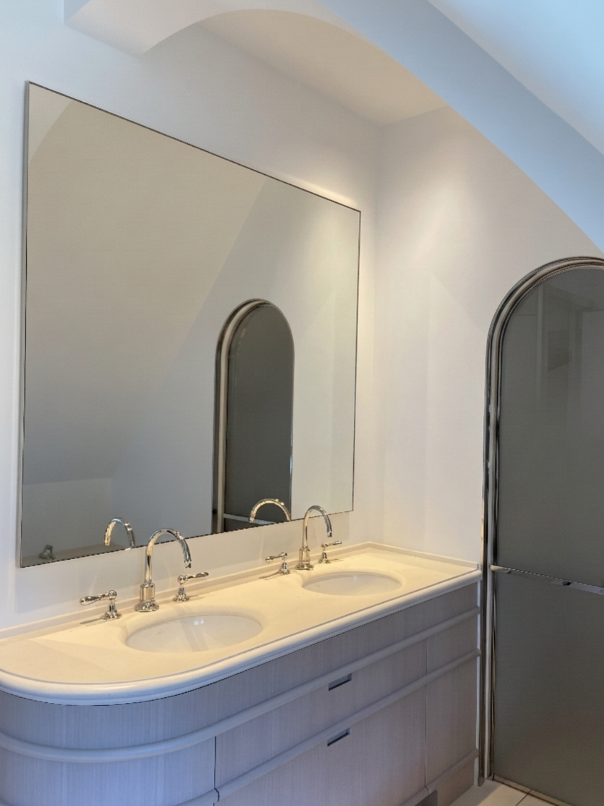 Double lavabo dans une salle de bain moderne avec grand miroir et porte de douche en verre