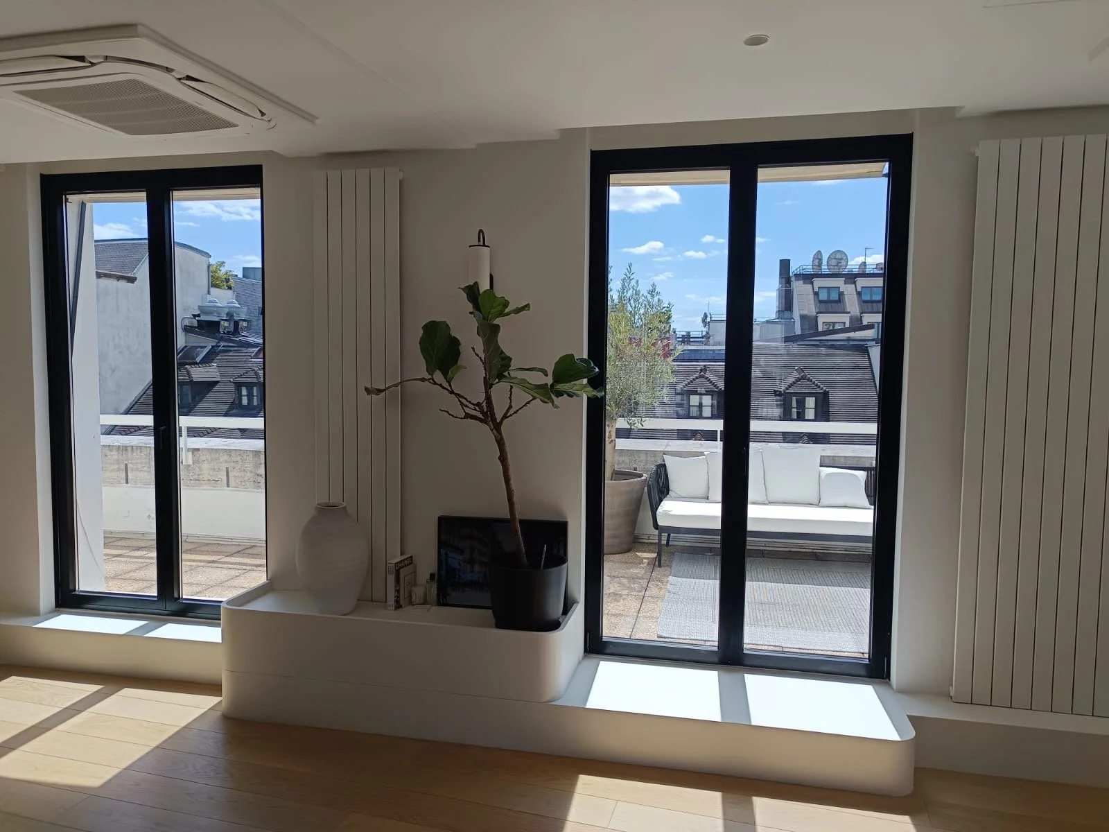 grande fenêtres en double vitrage donnant sur une terrasse sur les toit d'un immeuble hausmannien