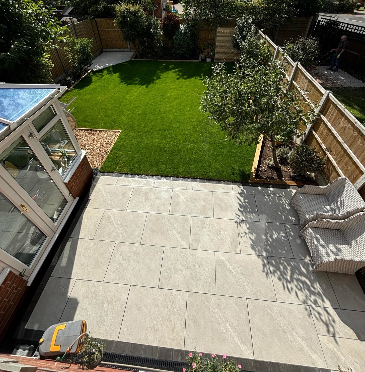 Garden transformation showing porcelain patio, fresh turf, fencing and seating area in Derby