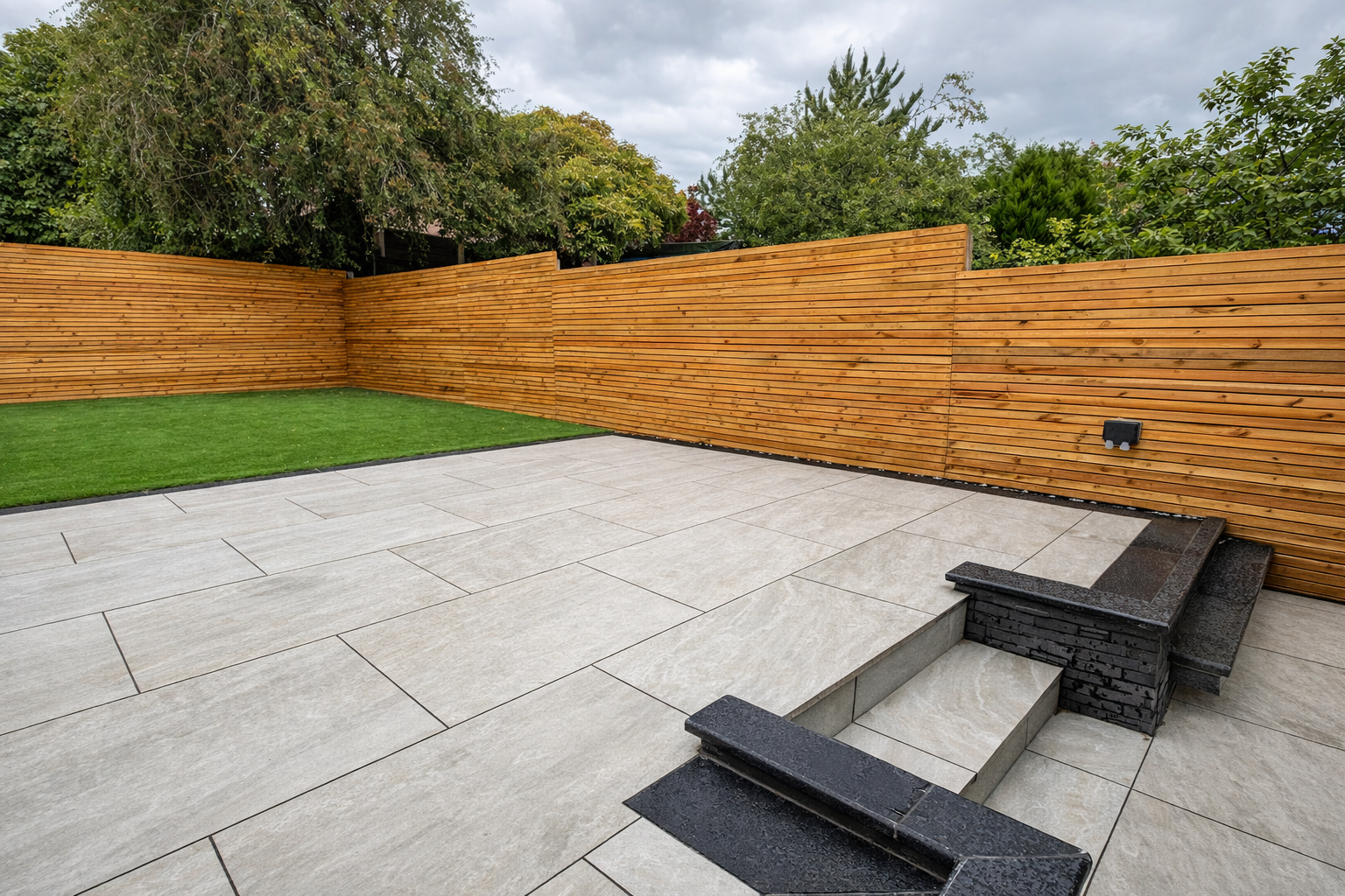 Porcelain patio, clad garden walls, steps, fencing and artificial turf.