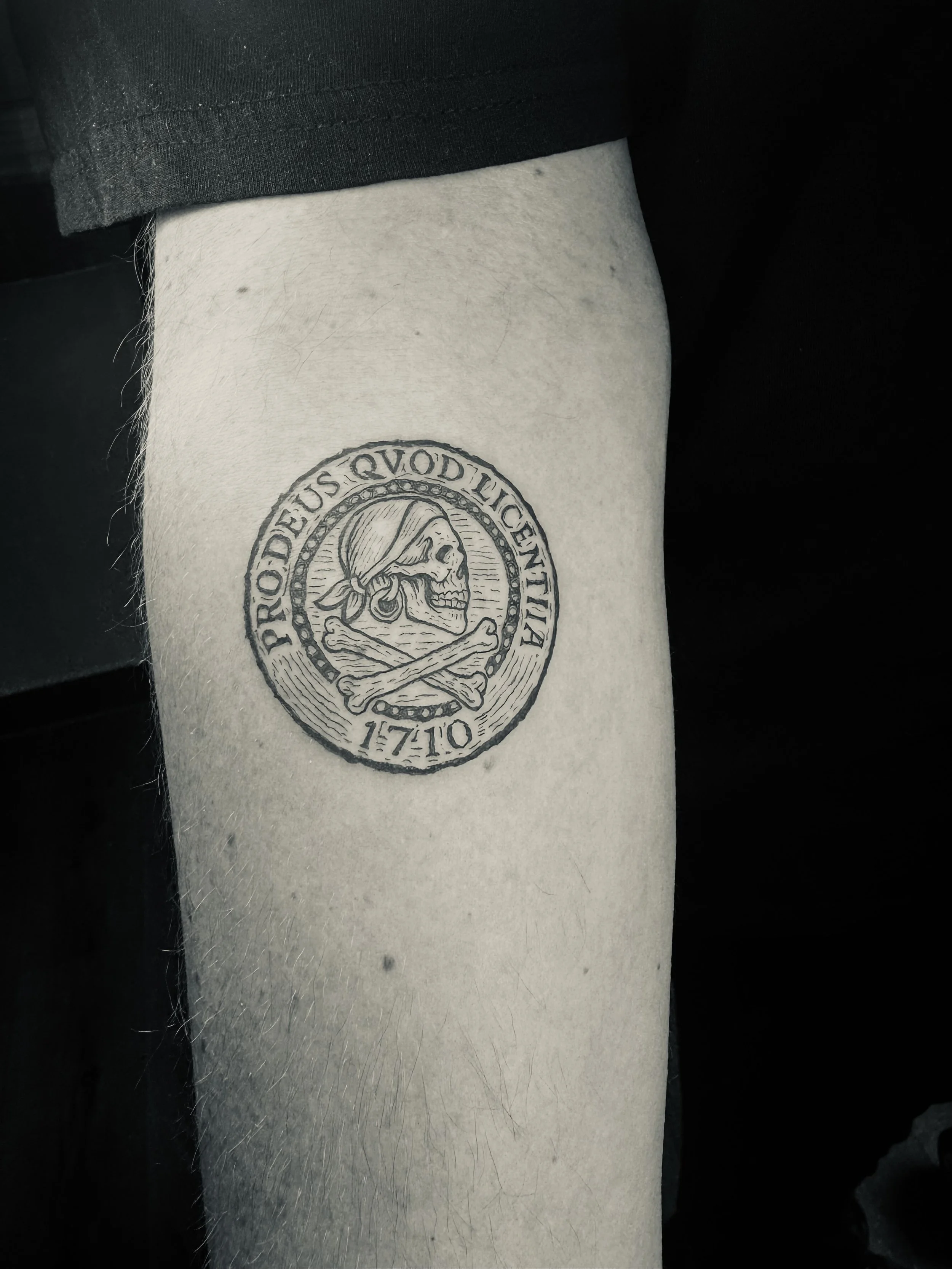 Schädel mit Bandana und zwei gekreuzten Knochen in einem Kreis, mit dem lateinischen Text 'PRO DEUS QVOD IUSTITIA' und dem Jahr 1770.