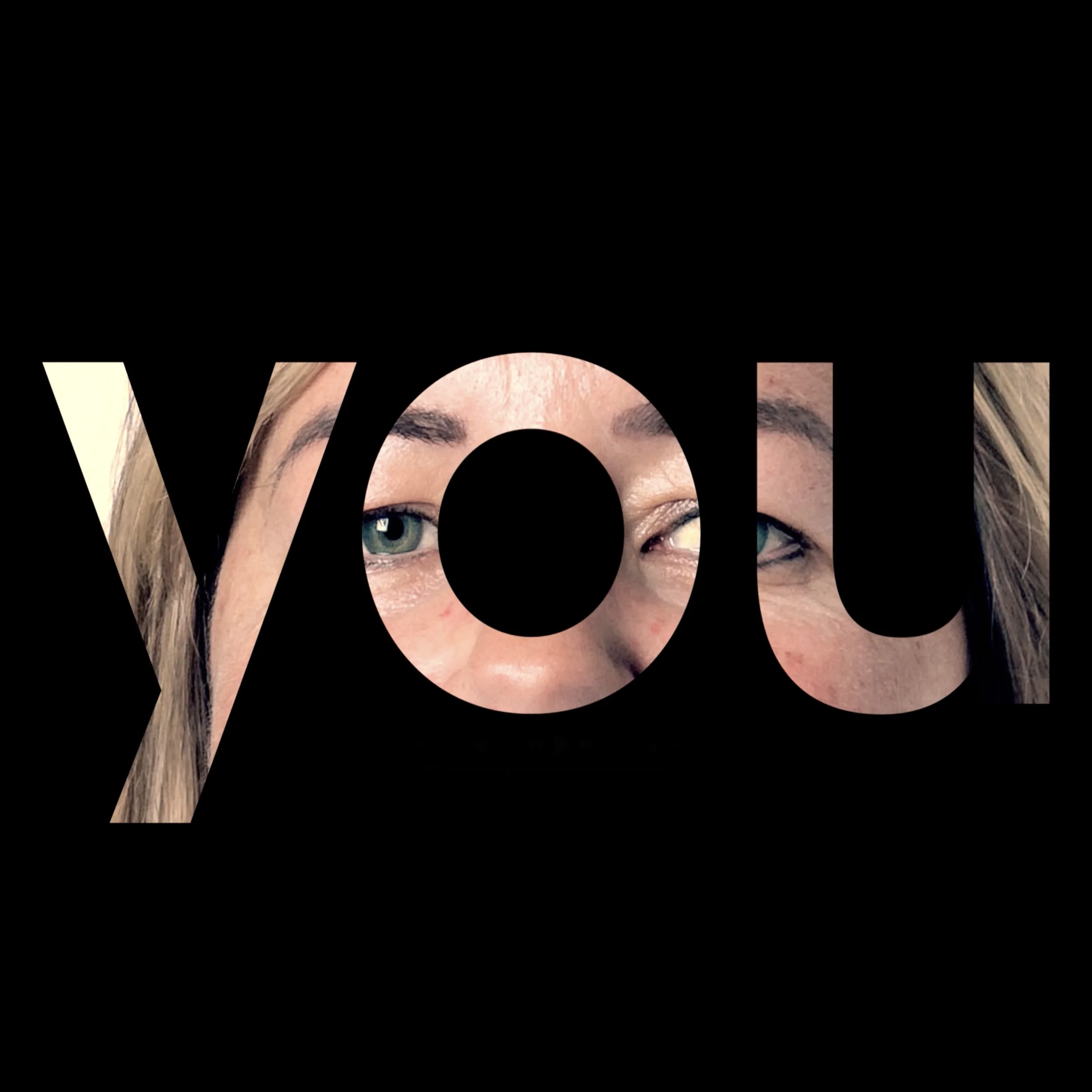 The word 'you' in large black font reveals a partial image of a person's face, showing eyes and eyebrows through the letters.