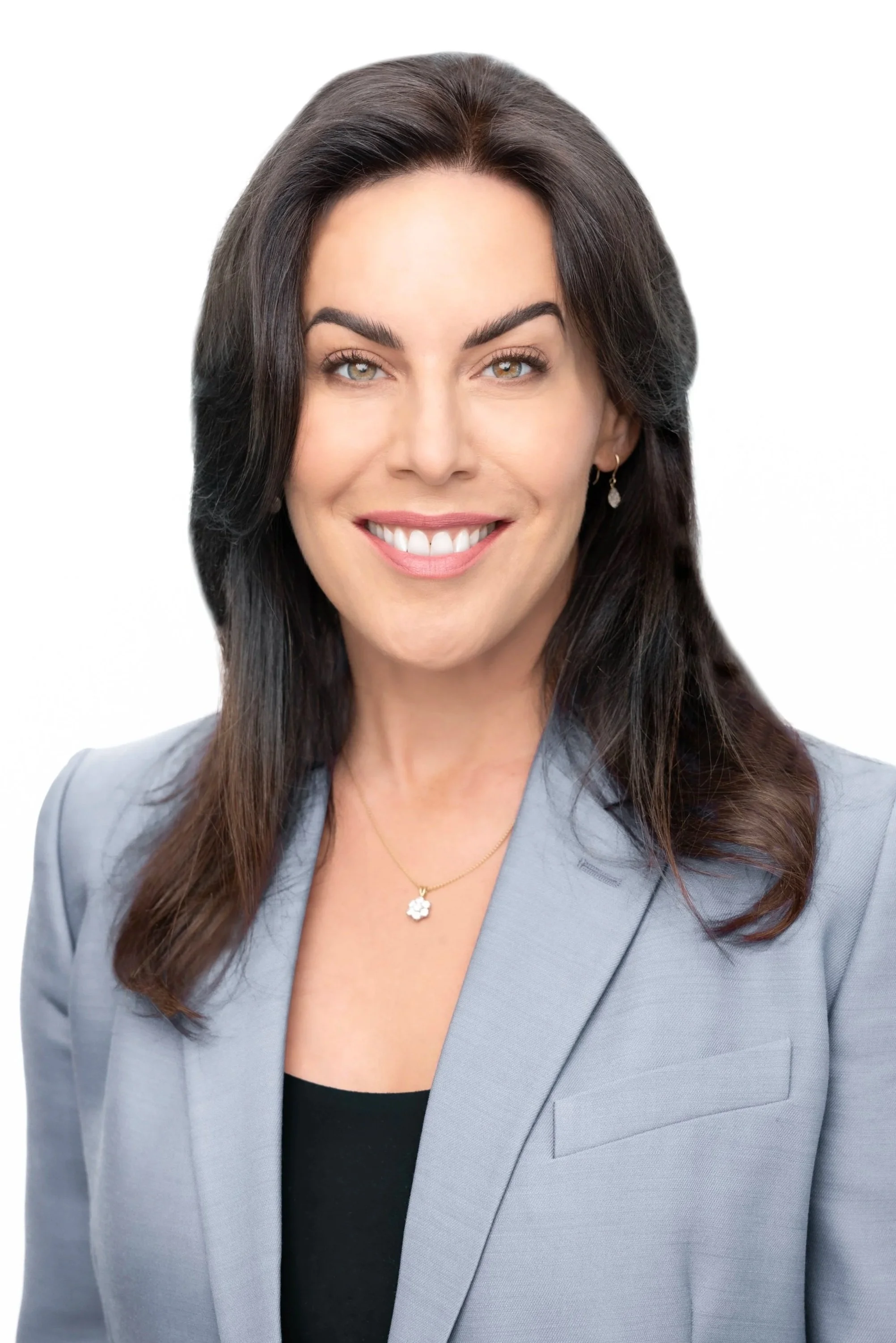 A woman with long brown hair, wearing a gray suit jacket over a black top, smiling with white teeth, against a white background.