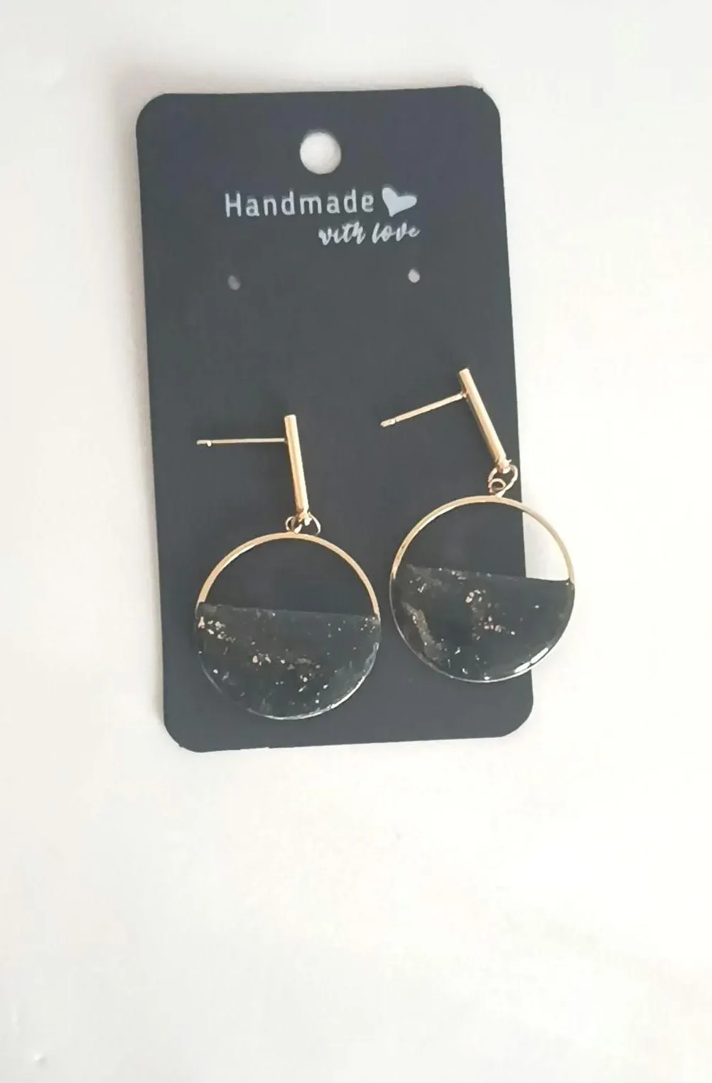 Minimalist red polymer clay circle earrings hanging from 14k gold-filled hooks. The round geometric dangles feature a matte red finish and are displayed on a white background.