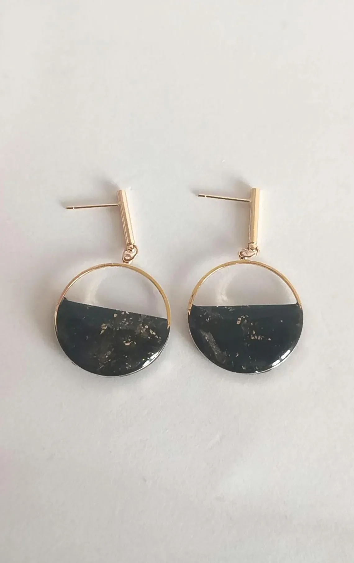 Minimalist red polymer clay circle earrings hanging from 14k gold-filled hooks. The round geometric dangles feature a matte red finish and are displayed on a white background.