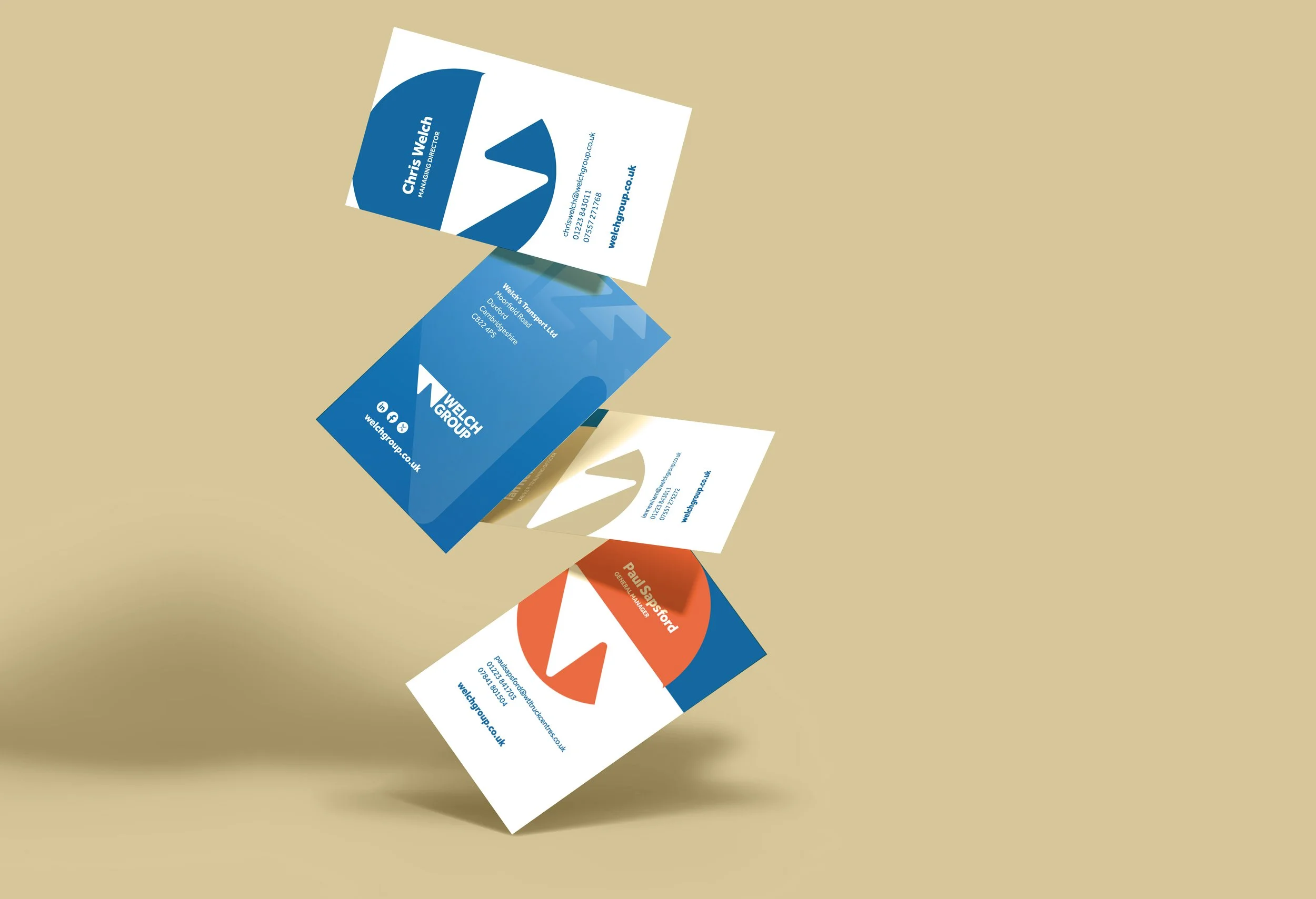 Falling business cards featuring Wells Group and Paul Gaspard with different color schemes and contact details, against a beige background.