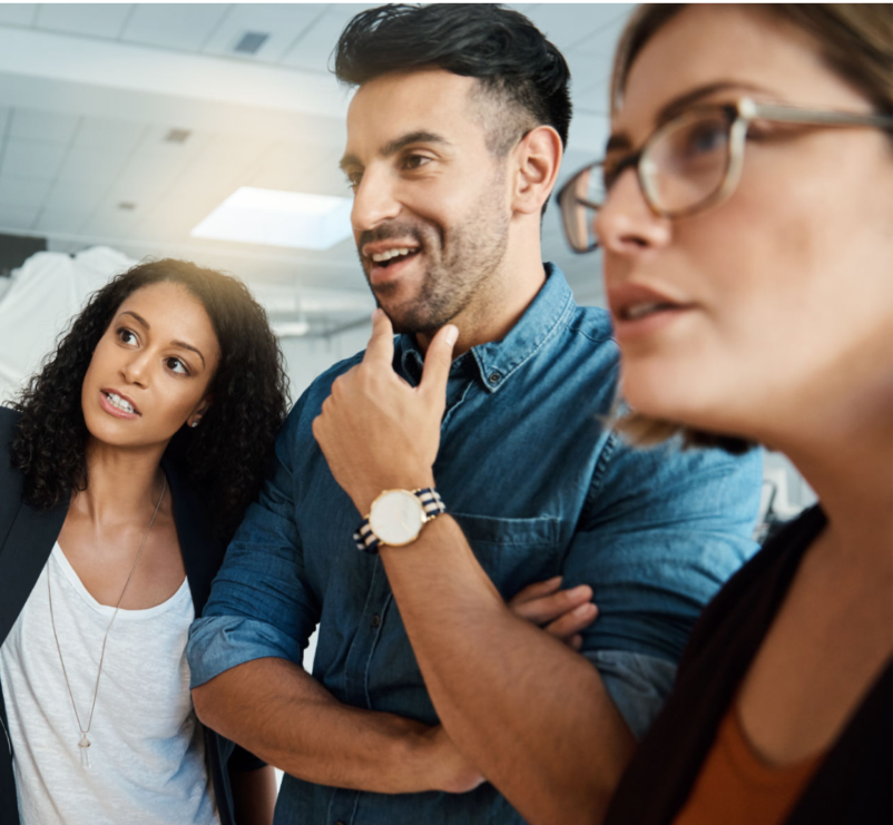 Three people engaged in a discussion in an indoor setting.