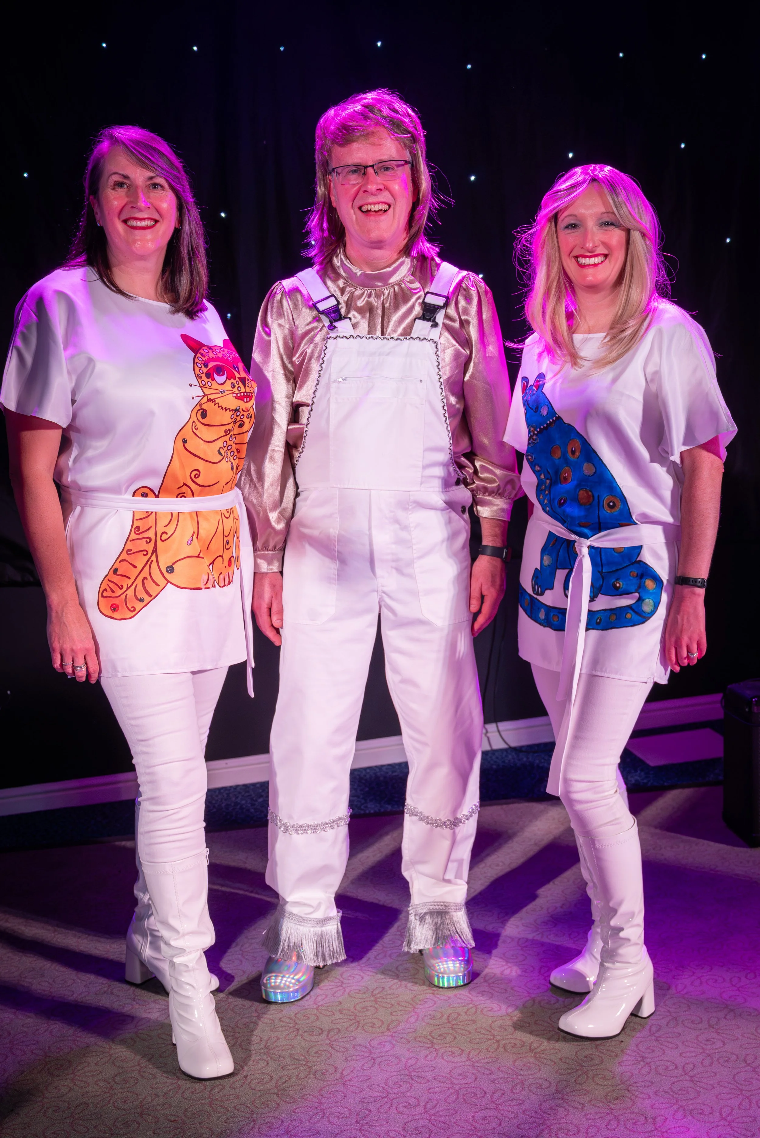 Take A Chance On three members Tina, Barry and Hannah pose for a photo prior to a performance of their ABBA tribute show live in Milton Keynes in November 2025.