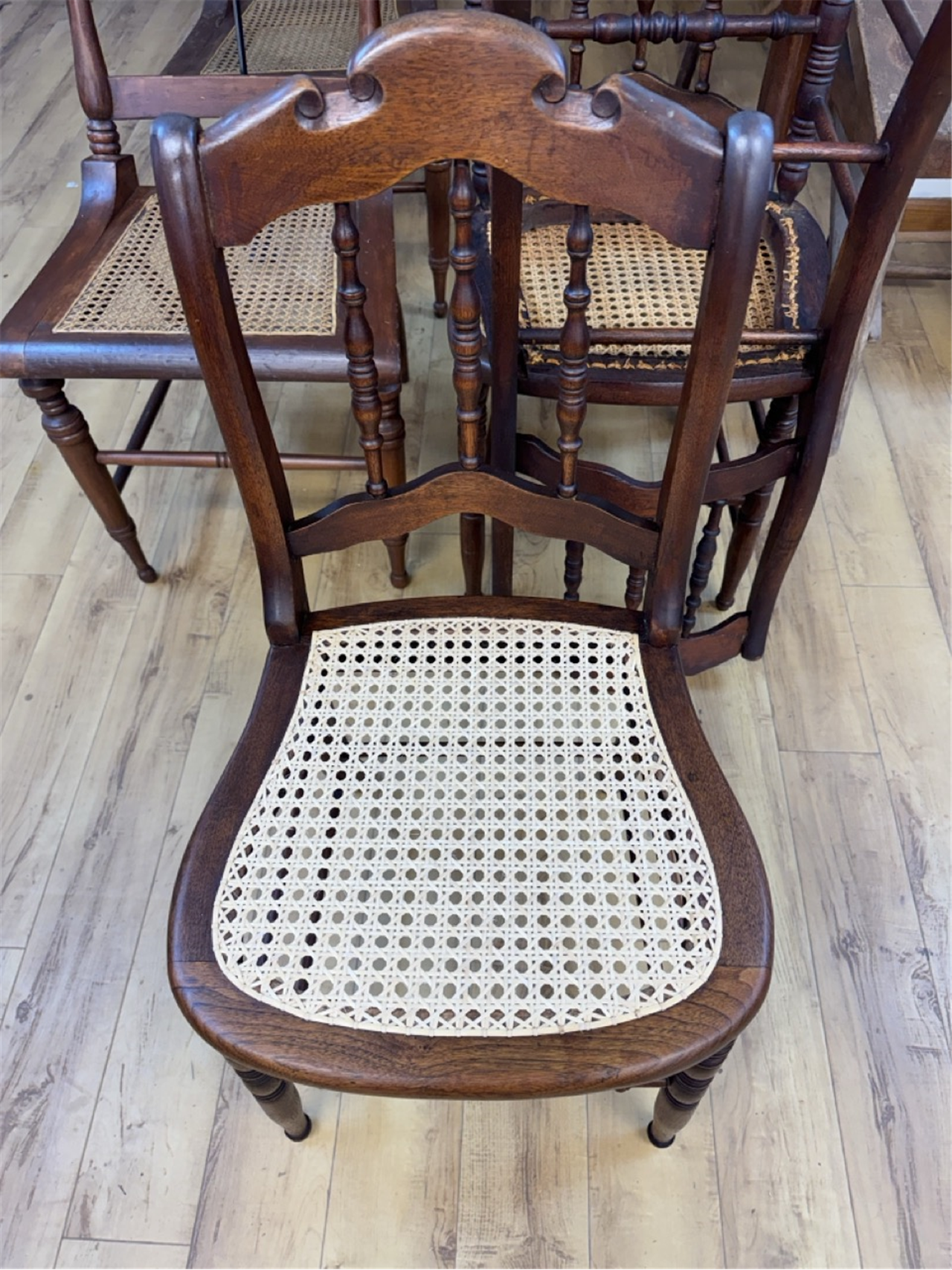 Antique wooden chair with freshly restored press cane seat in Asheville furniture workshop.