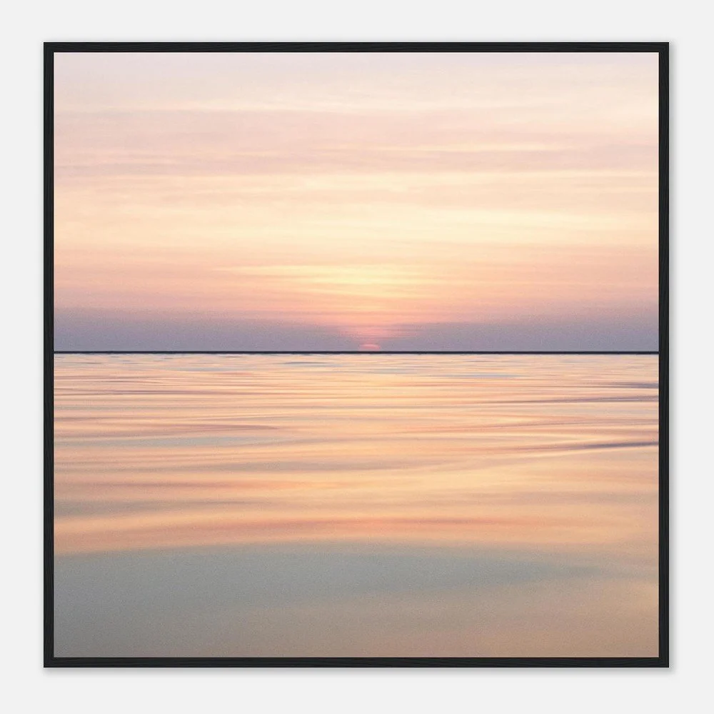 A serene sunset over calm water with pastel pink, orange, and purple hues reflected in the water.