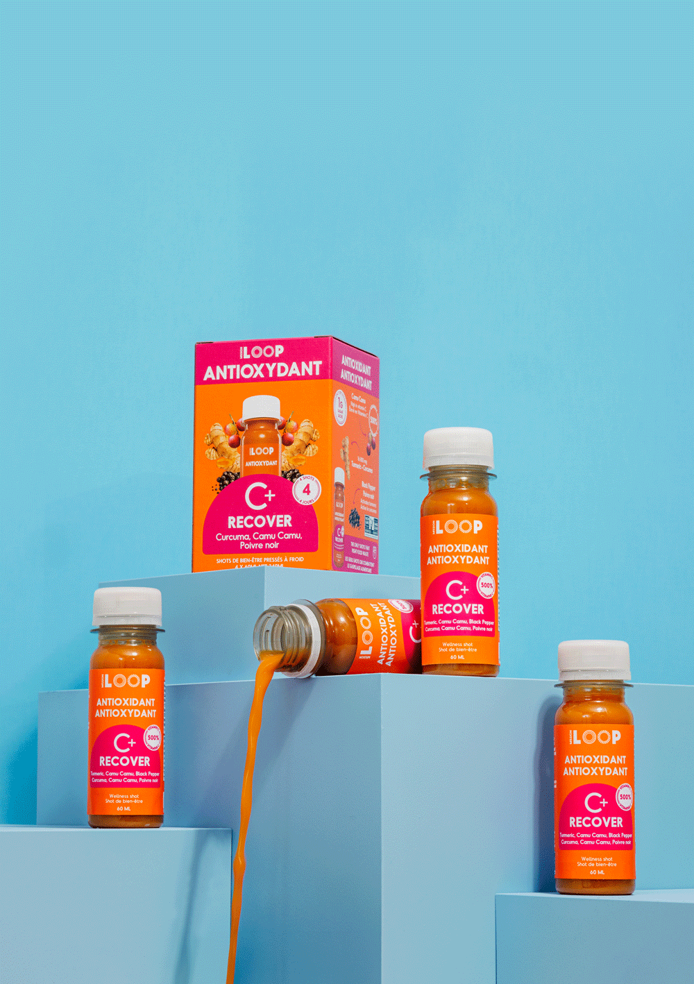 Four bottles of antioxidant supplement labeled 'LOOP' are arranged on blue geometric platforms. One bottle is tilted, pouring an orange liquid. The packaging features bright orange and pink colors with text indicating it is for recovery and contains turmeric, camu camu, and black pepper.