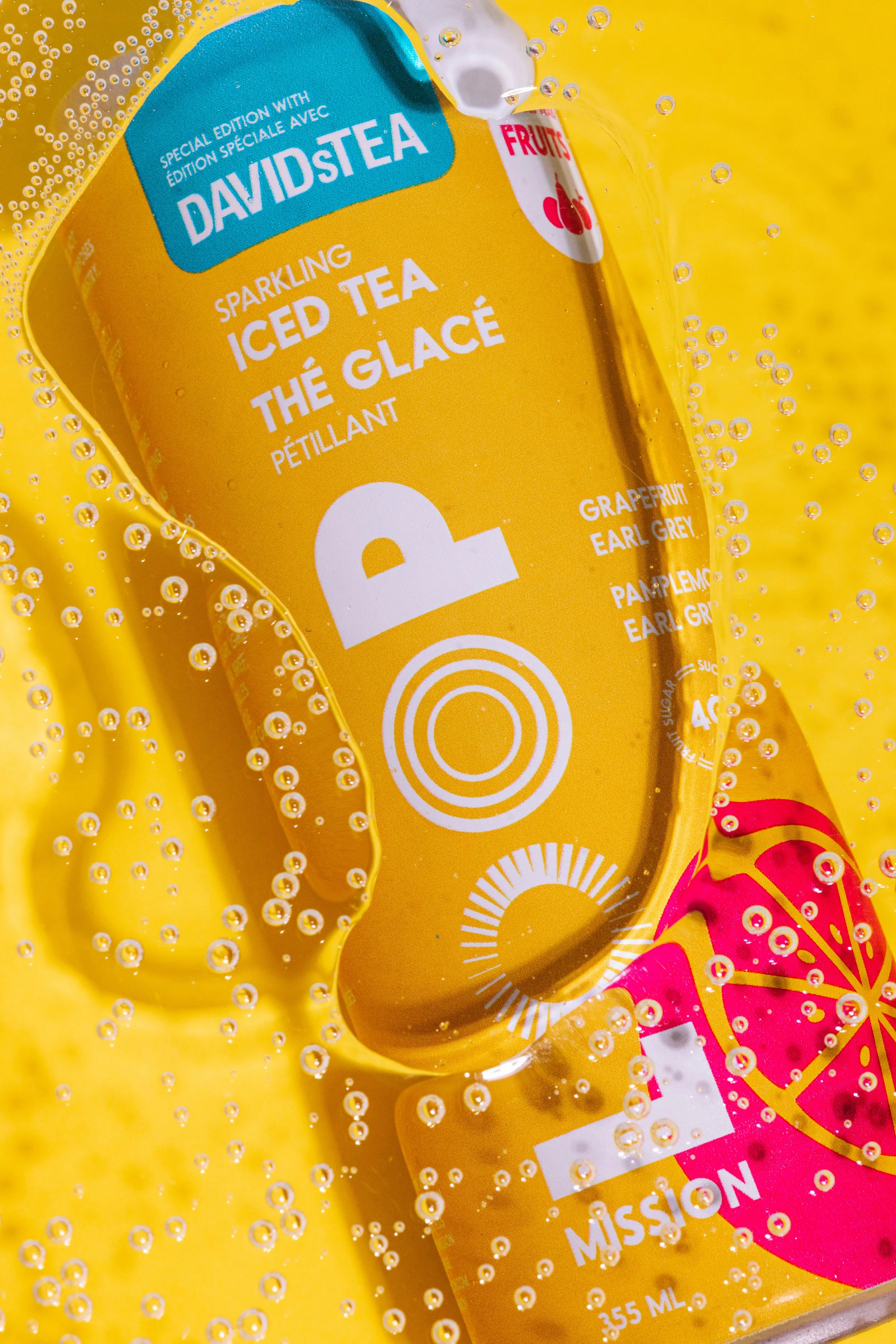 Yellow packaging of David’s Tea sparkling iced tea, flavor grapefruit Earl Grey with bubbles on yellow background.