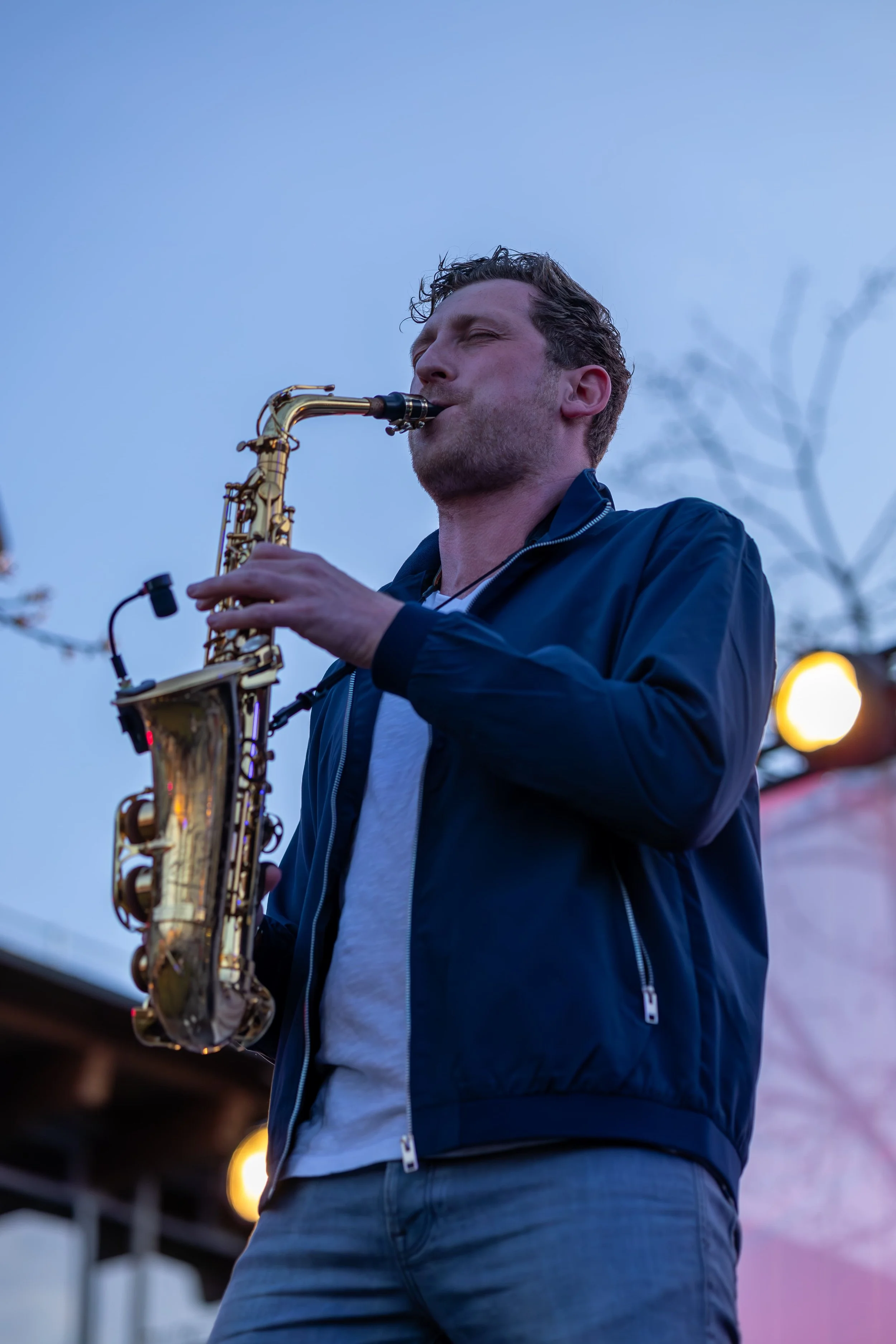 Frederik Heckel spielt auf einem Saxophon bei Dämmerung im Freien.
