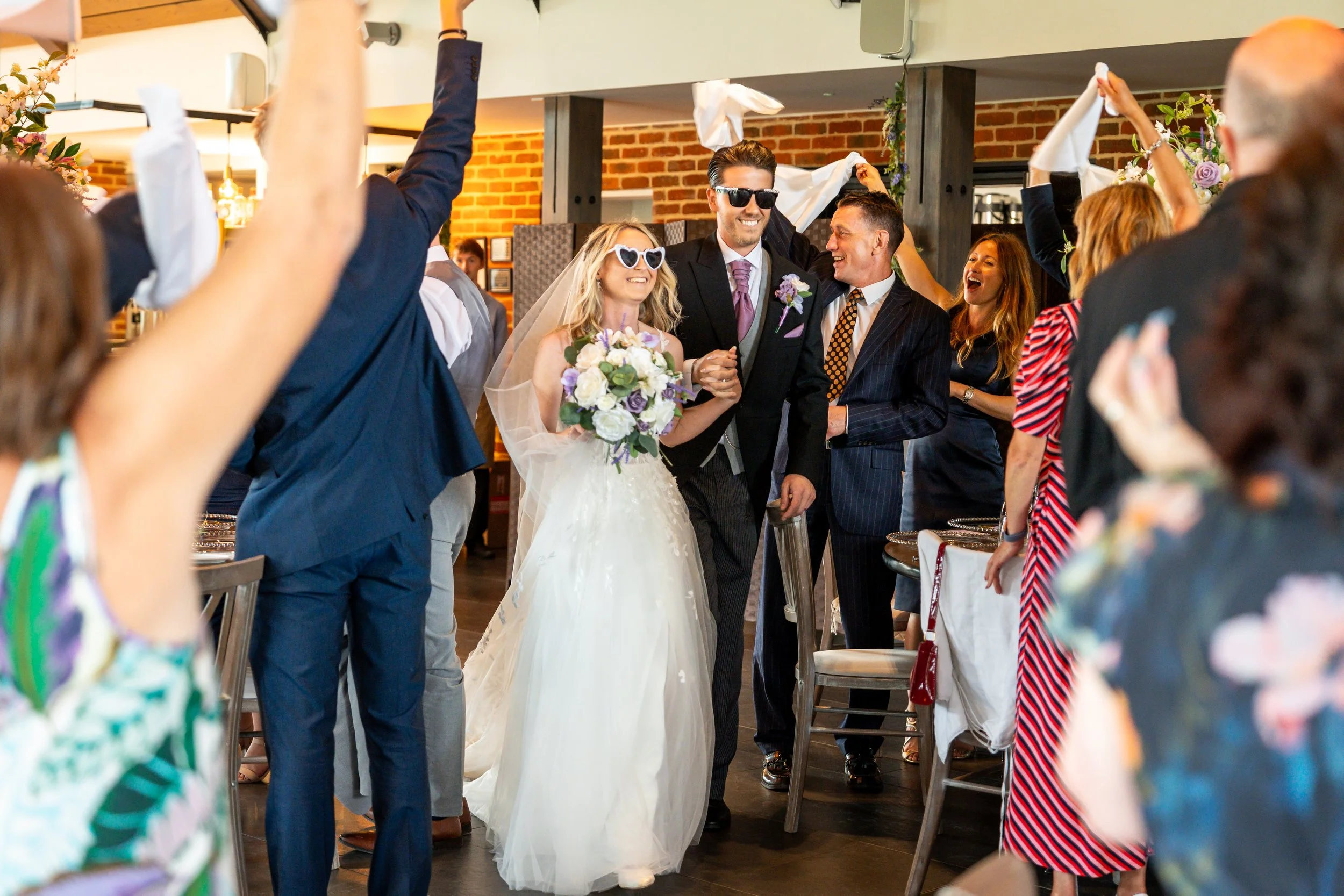 Bride & groom being welcomed into the wedding breakfast at Syrencot