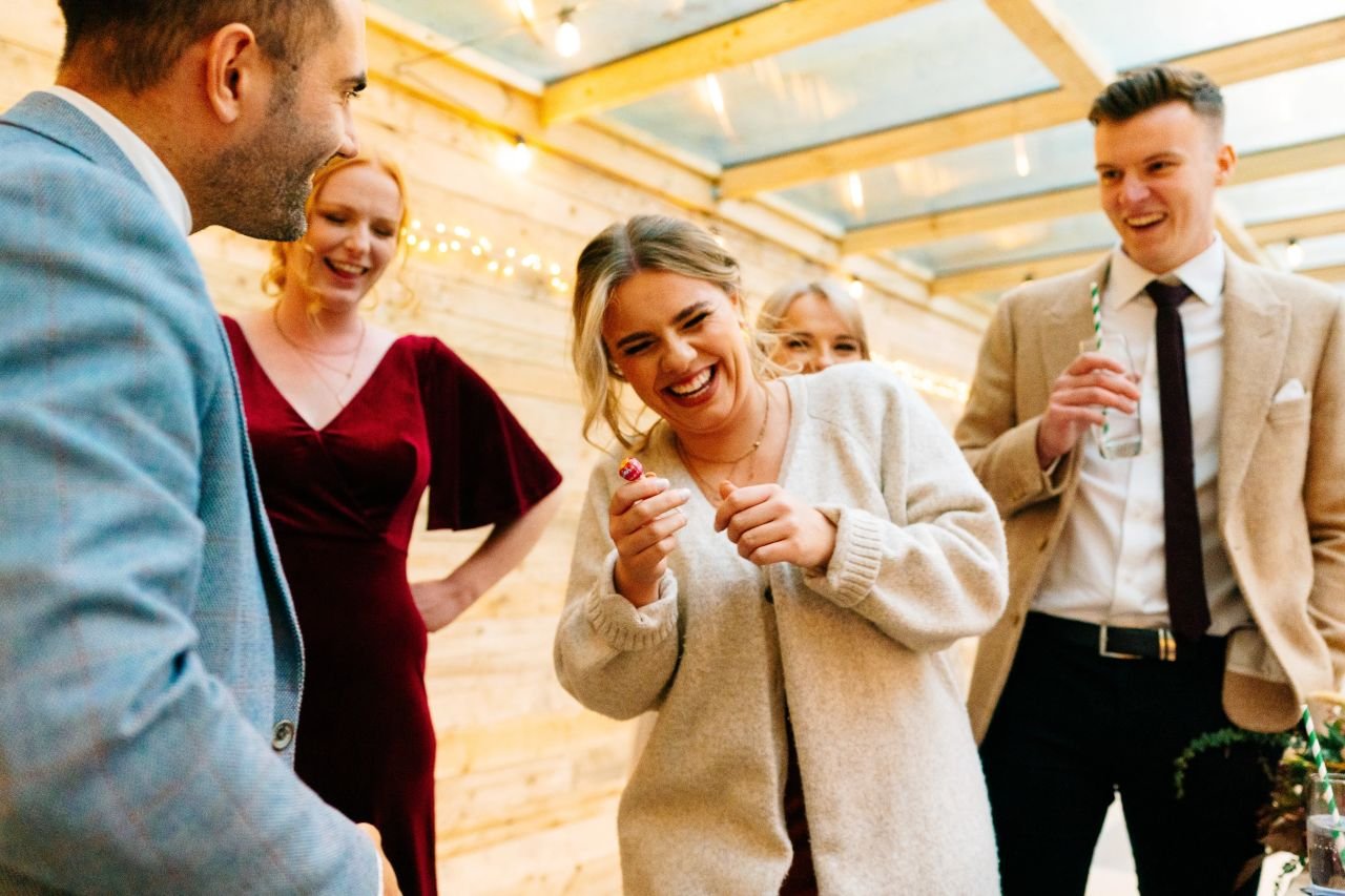Professional magician performing close-up magic for guests at a summer garden party