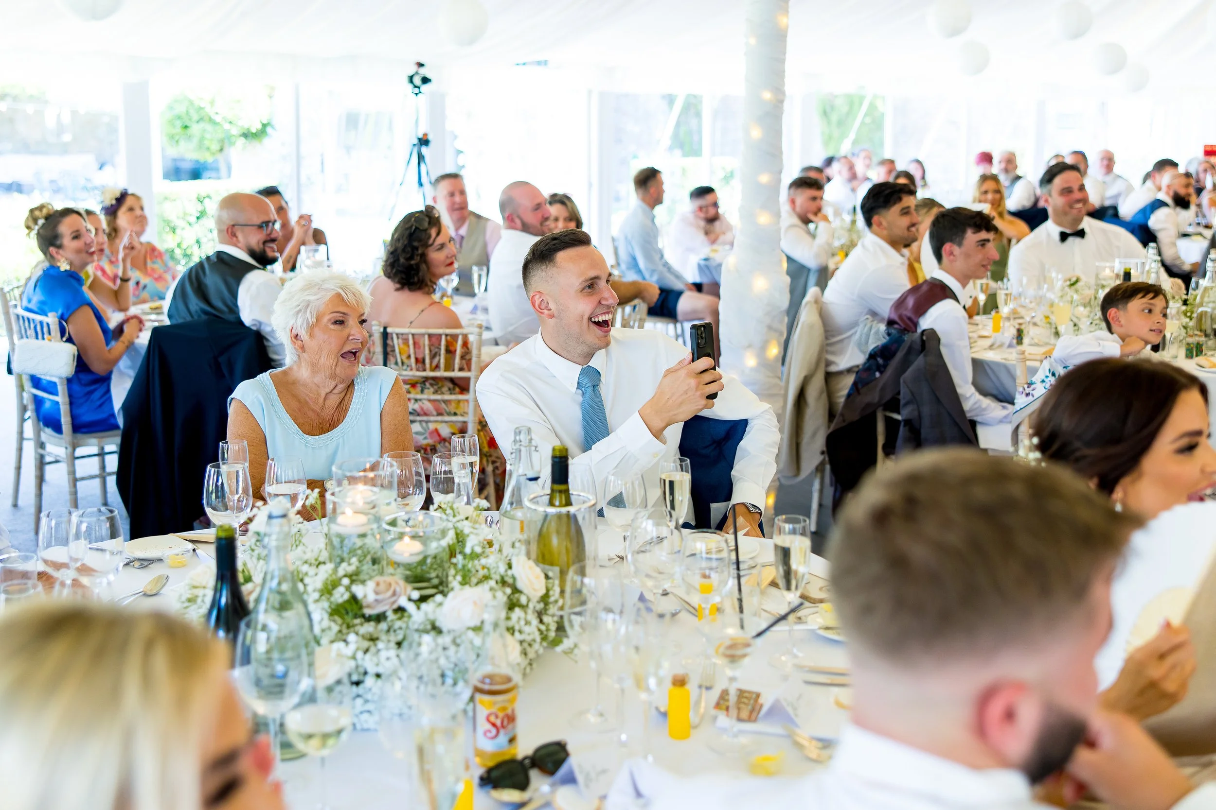 Wedding guests laughing at magic during the wedding breakfast at Parley Manor, Dorset