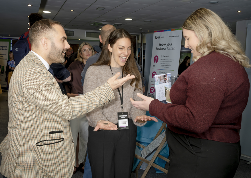 Magician performing close-up coin trick for delegates at business networking event