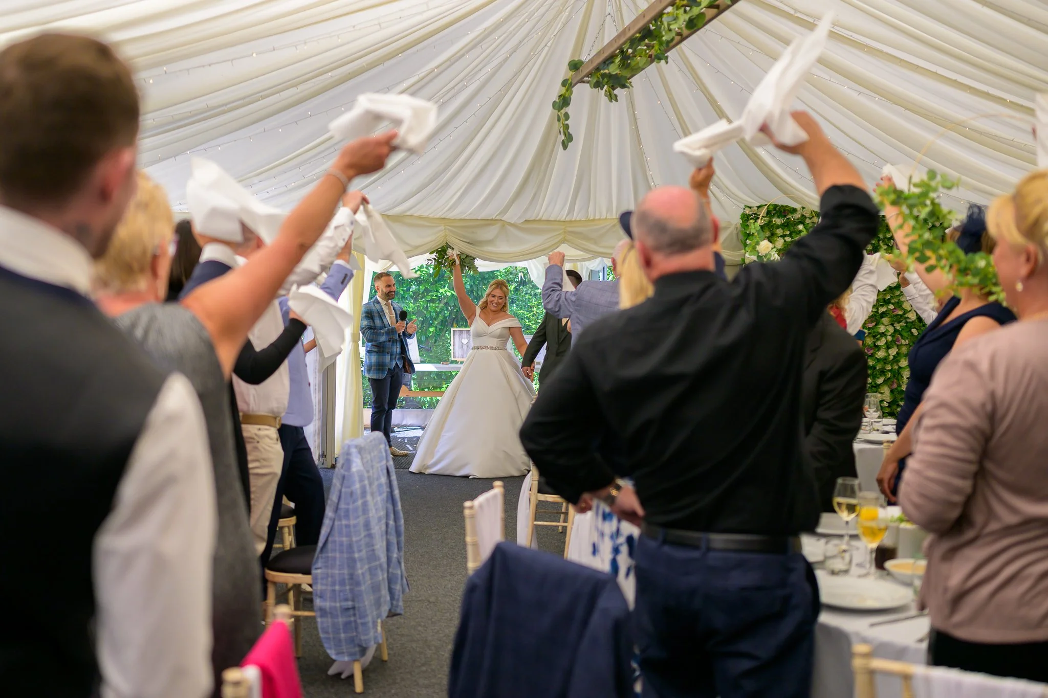 Wedding host introducing bride and groom into wedding breakfast