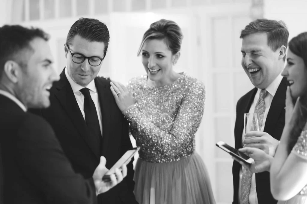 Corporate Christmas party guests laughing and reacting to a close-up magic performance