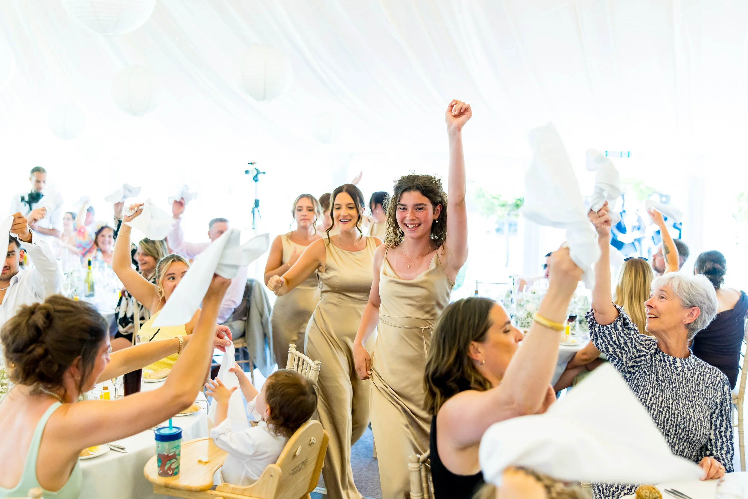Bridesmaids dancing whilst being announced into the wedding breakfast marque at Parley Manor